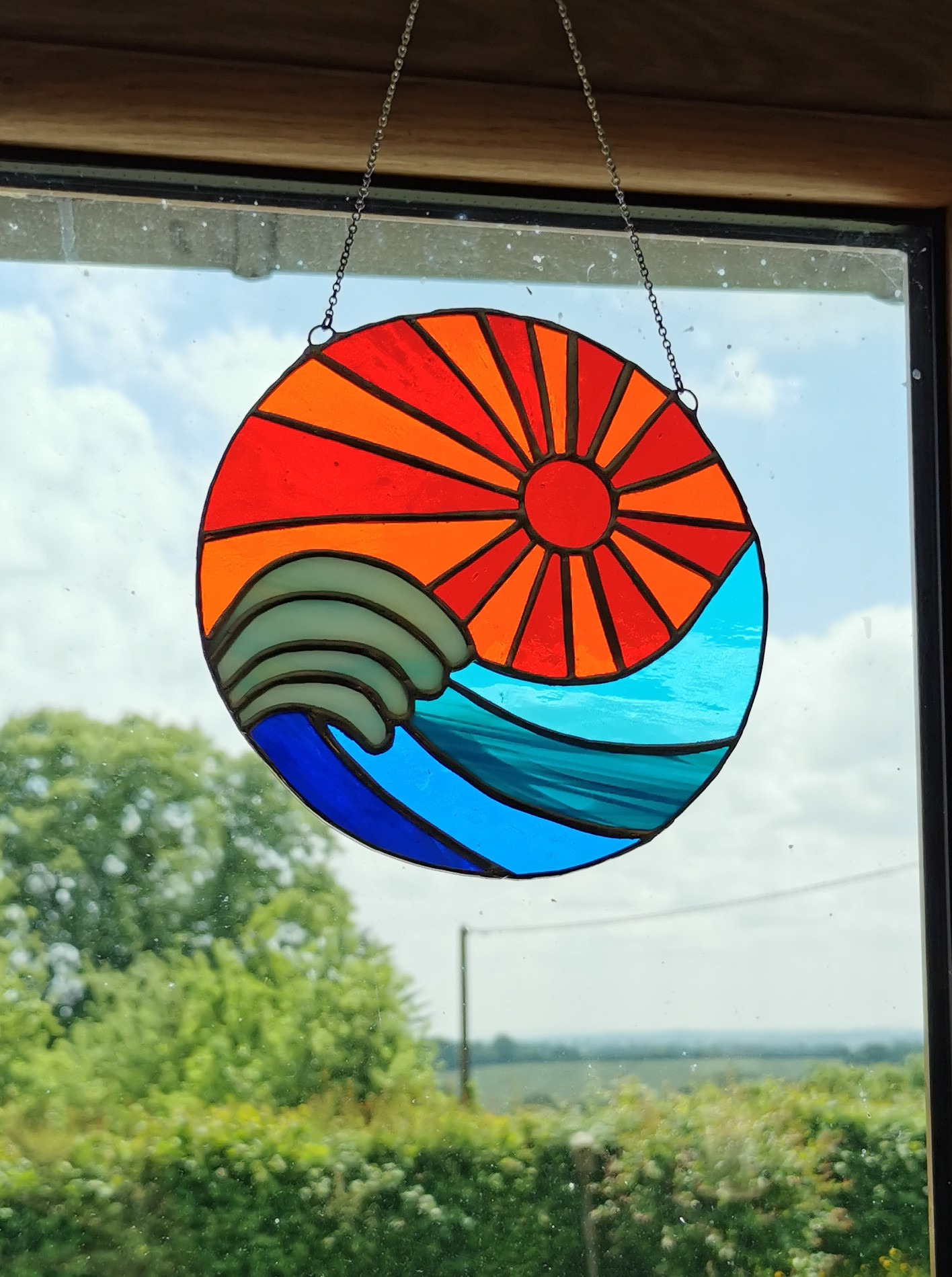 a sun catcher with a sun shining through the window