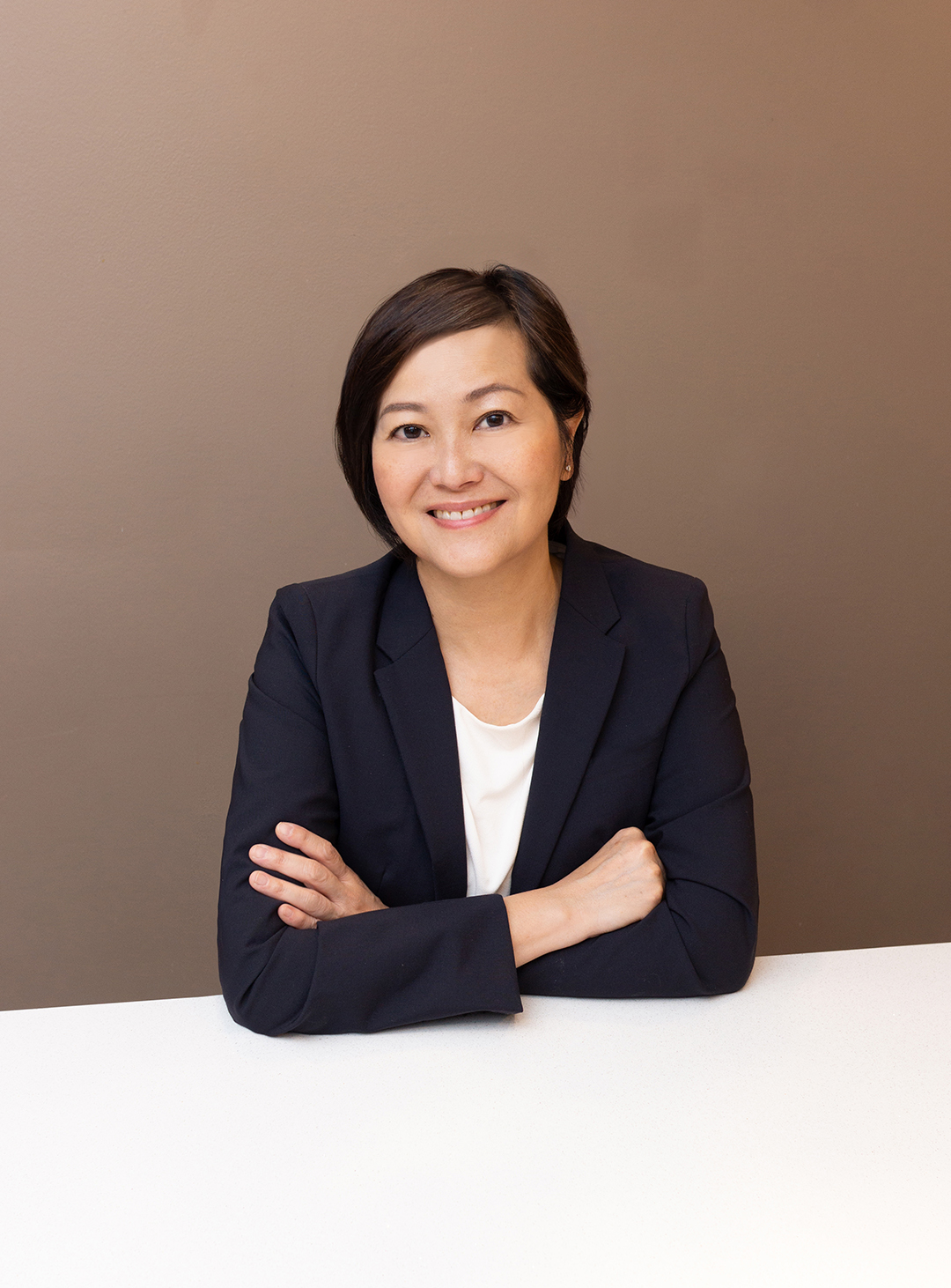 a woman in a suit and white shirt smiling