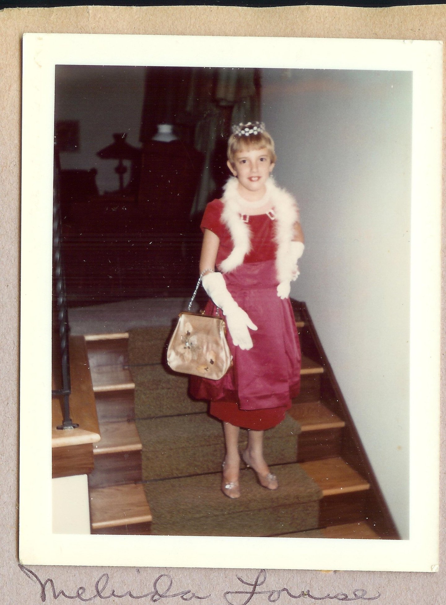 a young girl in a red dress and white fur stole