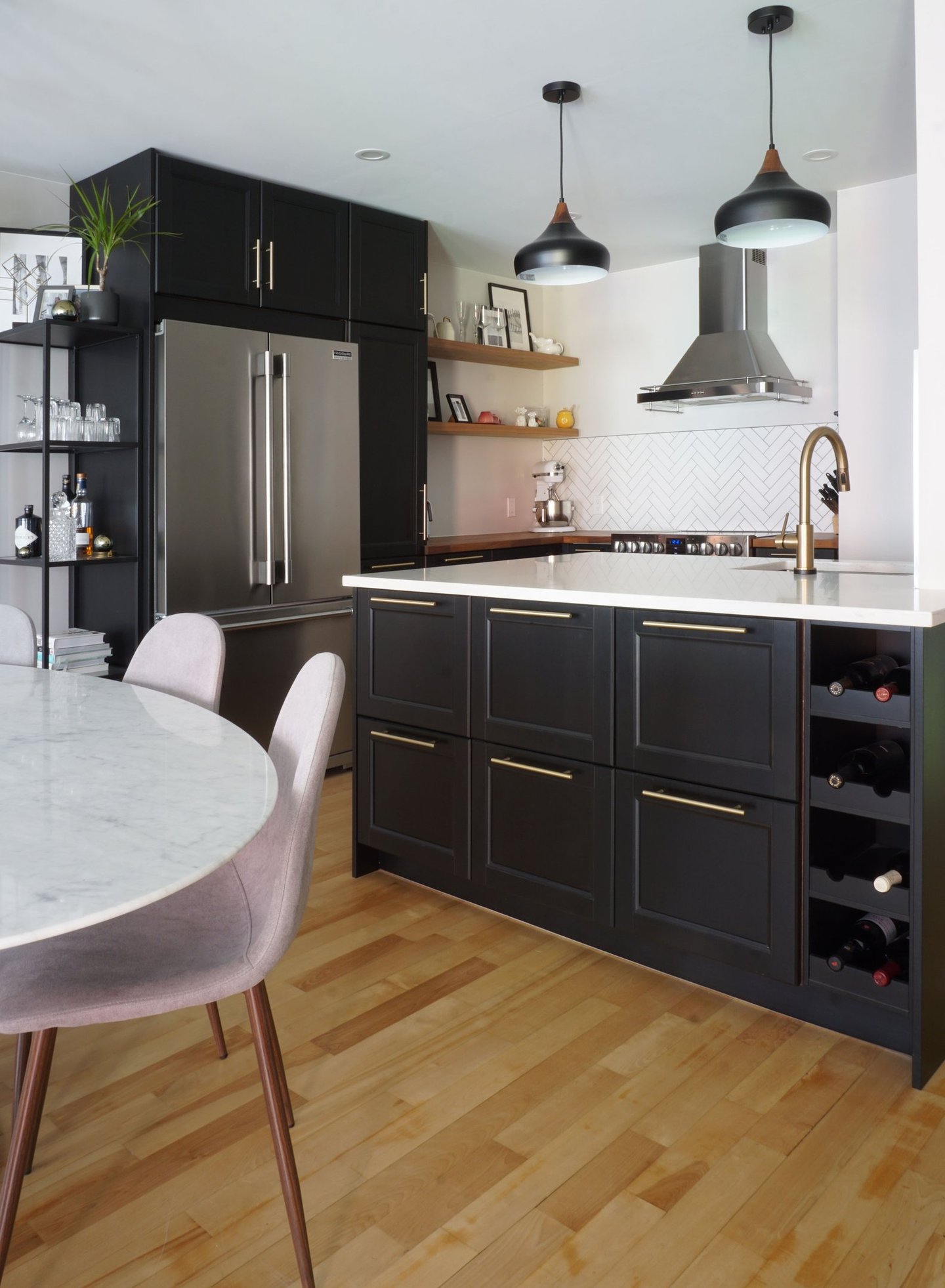 a black kitchen with a marble tulip table and chairs