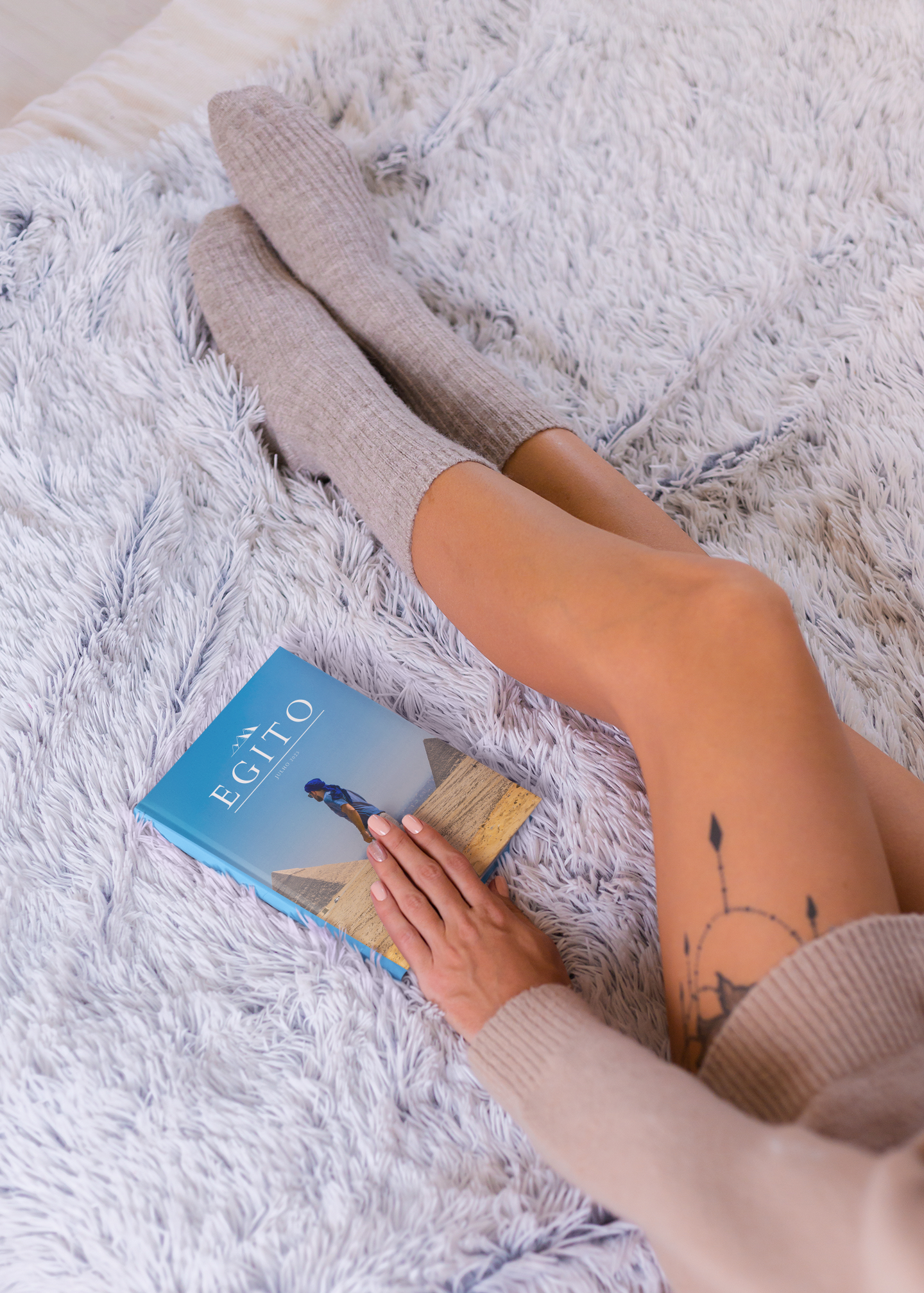 Álbum de viagem do Egito sobre manta felpuda em momento de relaxamento.