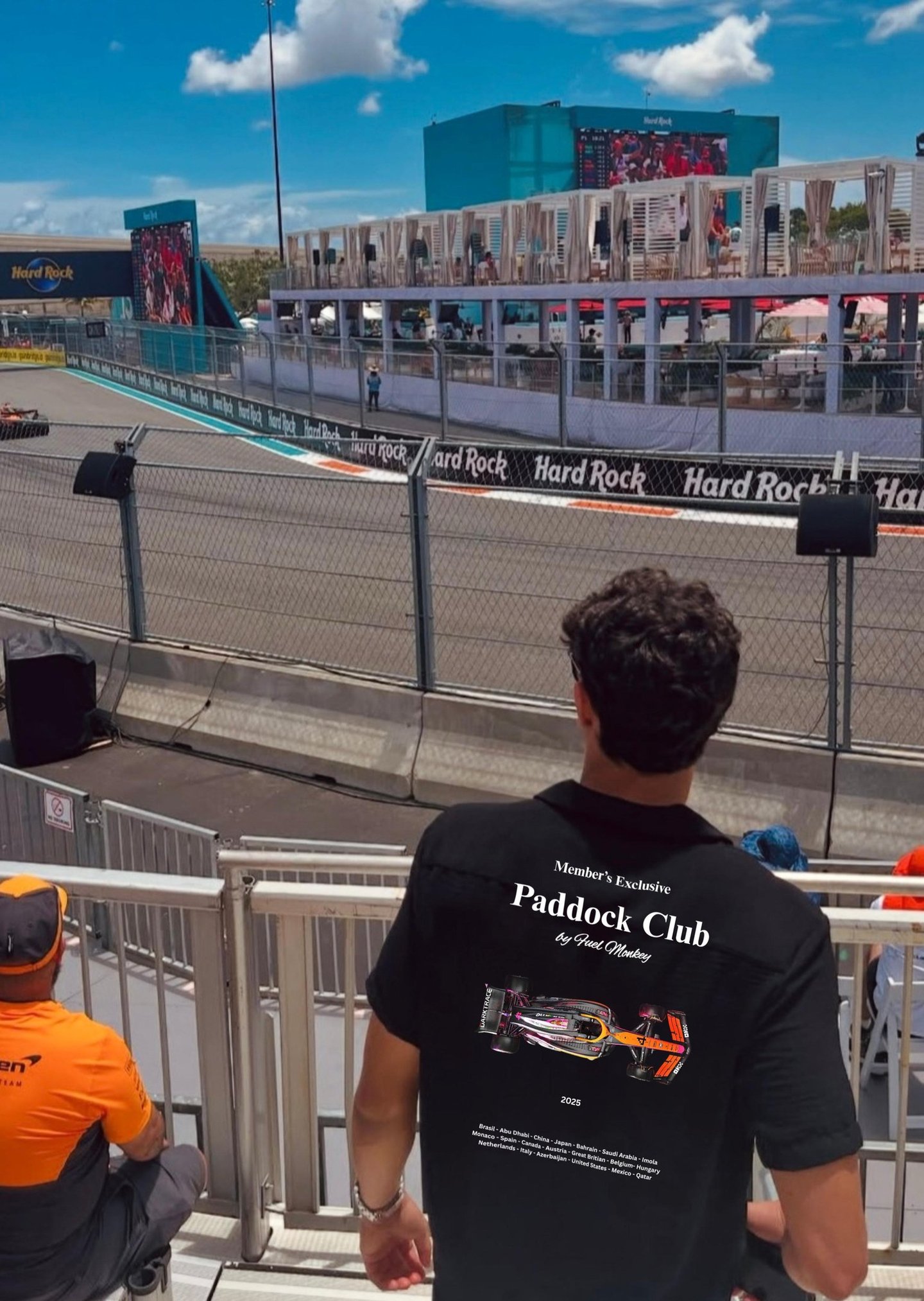 Person wearing FuelMonkey Paddock Club t-shirt watching a racing event at Hard Rock track, represent