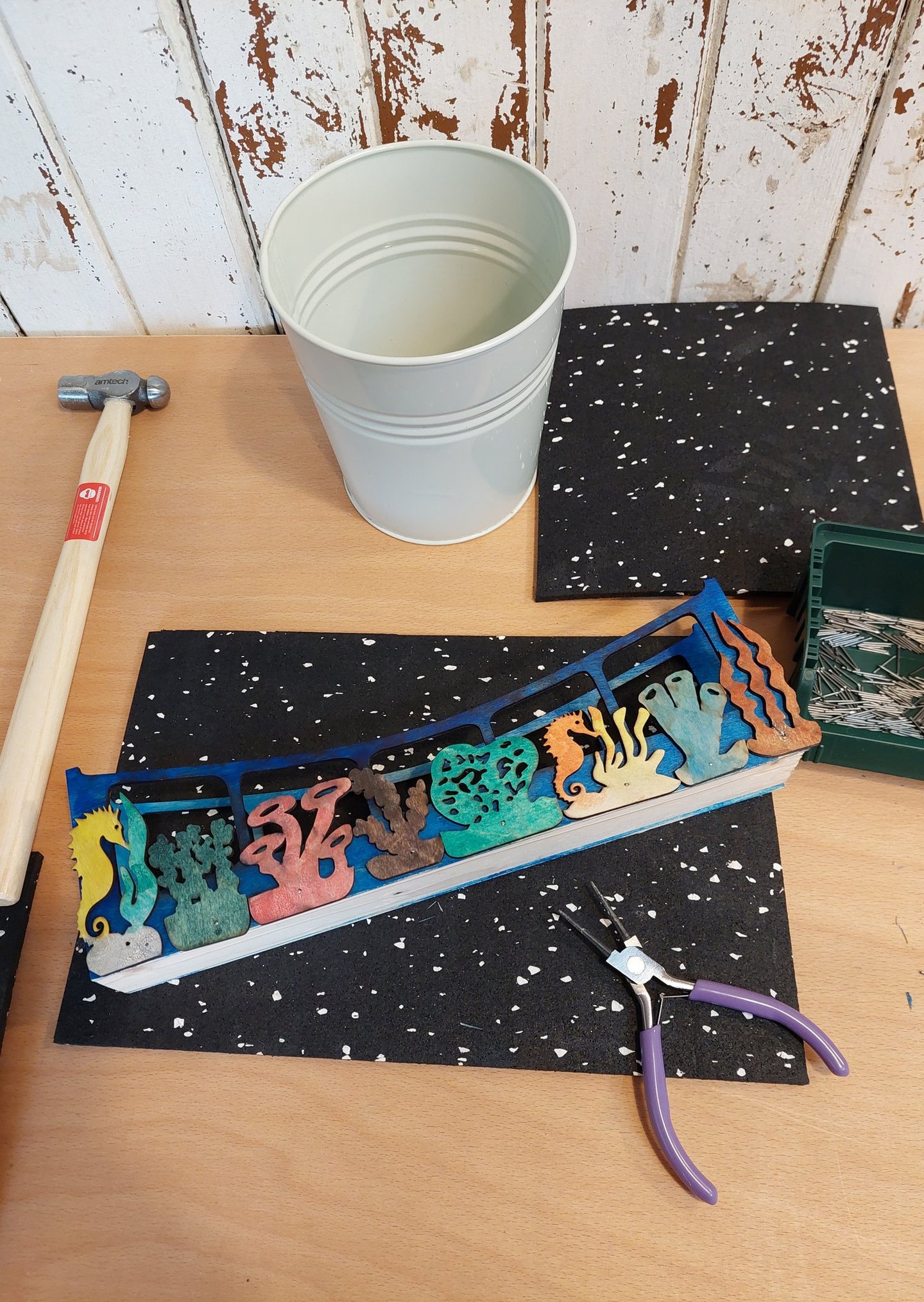 A work bench with hammer, pliers, bucket and under the sea themed wooden diy project