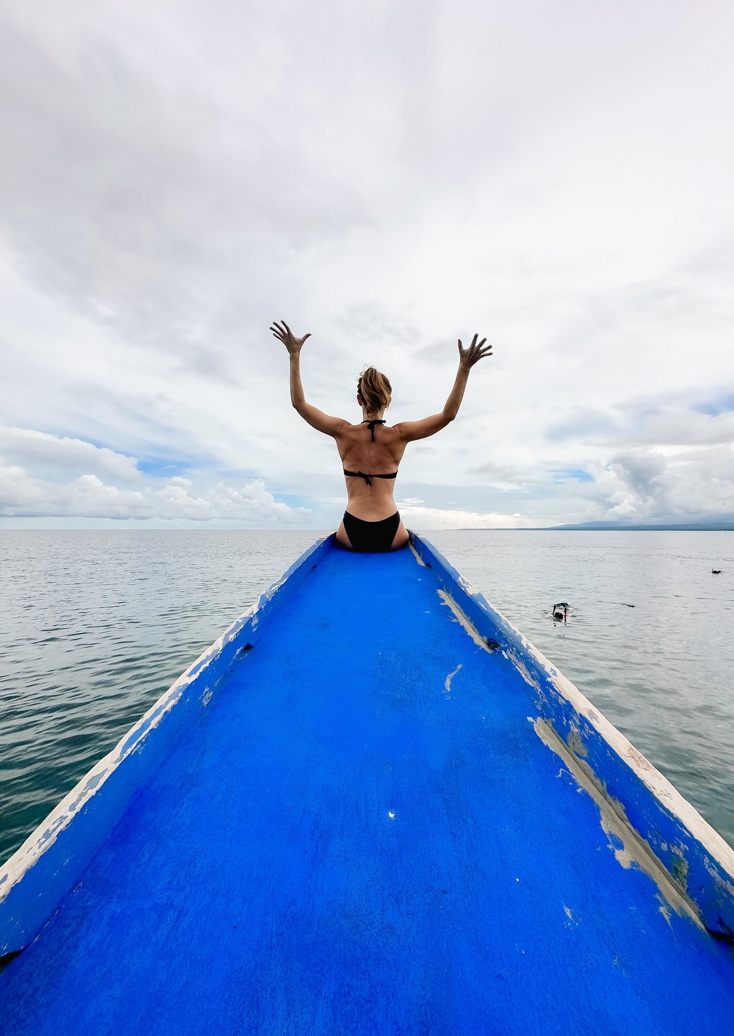 a man sitting on a boat in the ocean