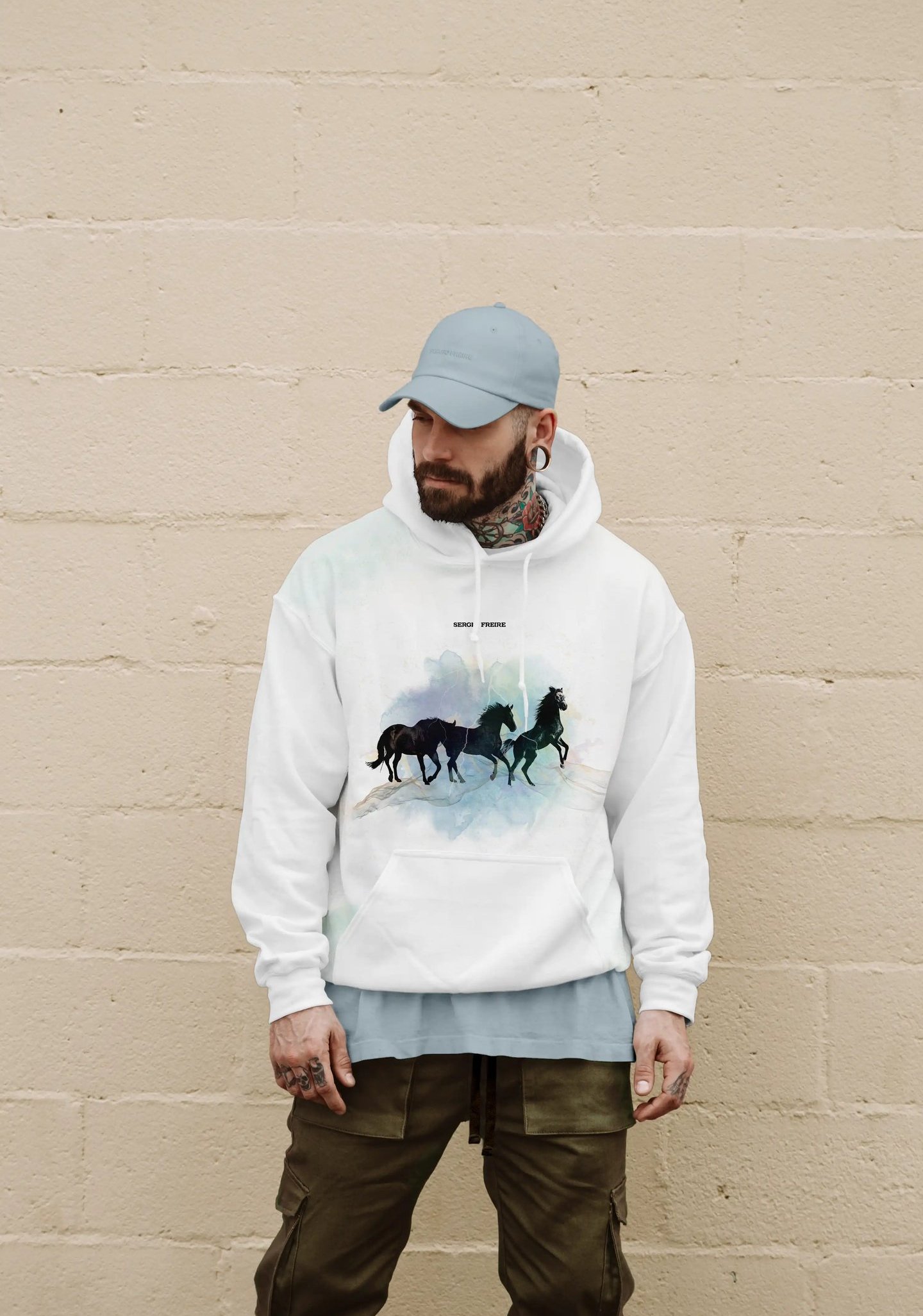 Hombre tatuado con una sudadera con el logo de Sergio Freire bordado en negro