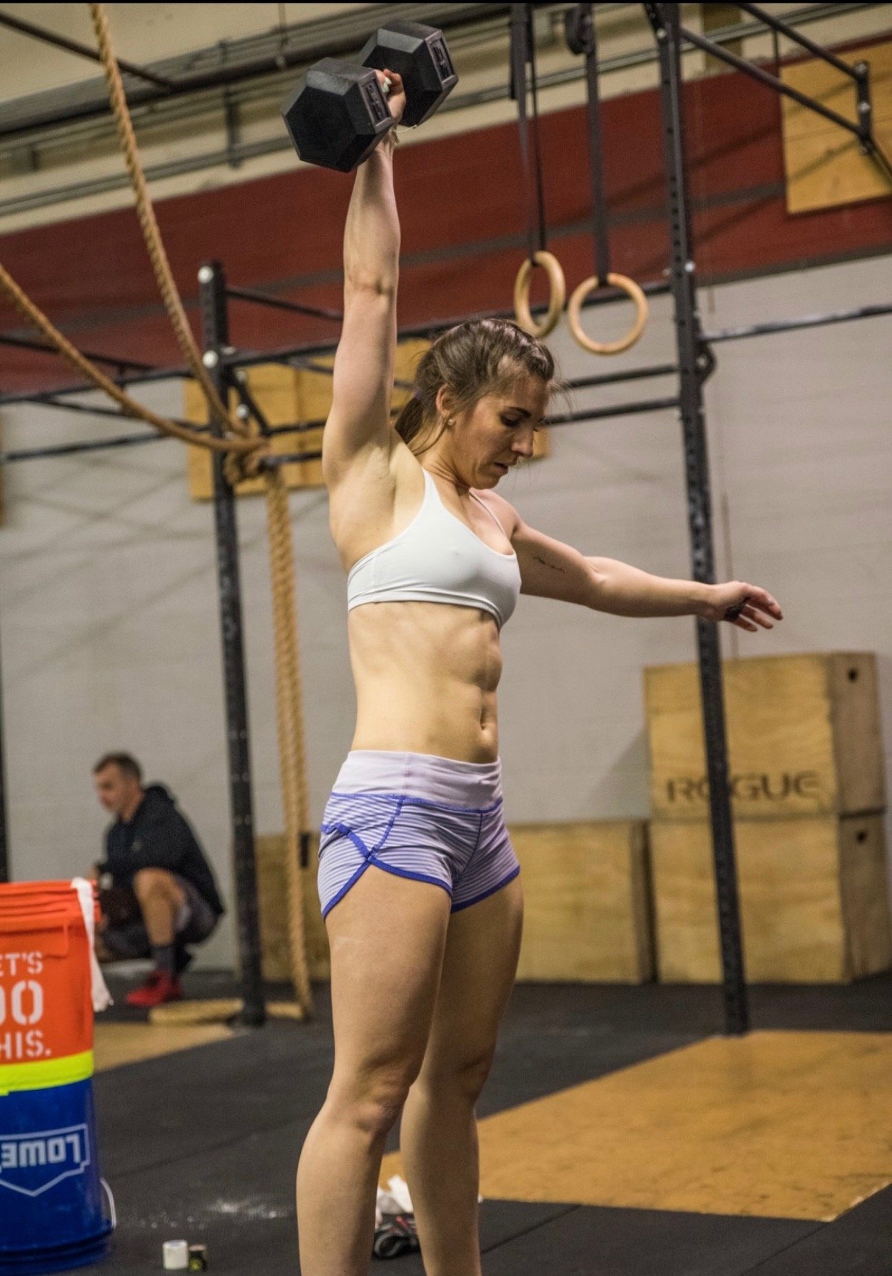 a woman in gym attire holding a kettlebell