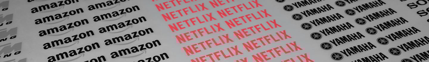 DTF textil mostrando logos impresos de Amazon, Netflix, Yamaha