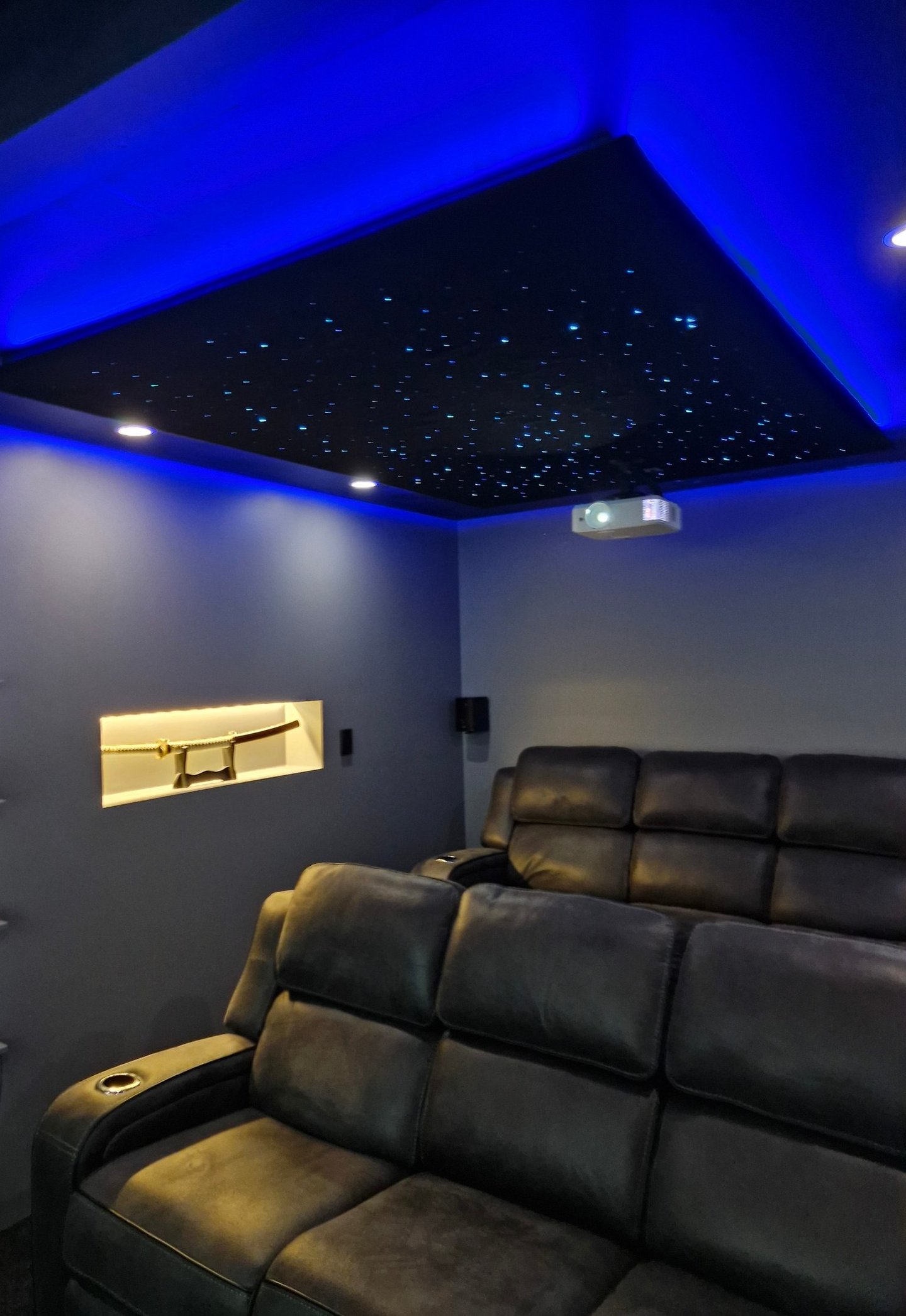 A cinema room with downlights and a star lighting ceiling