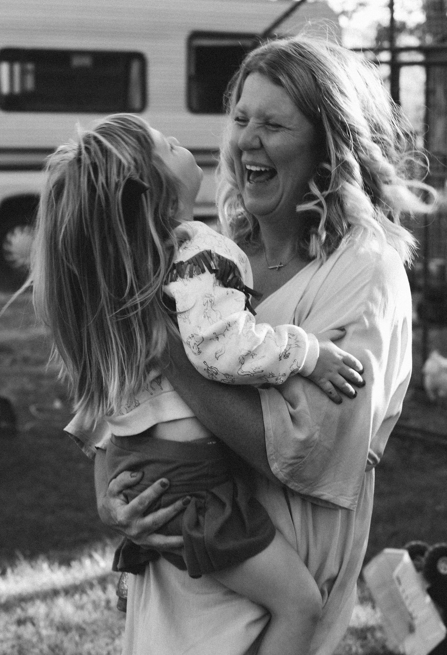 a woman laughing and holding a child in her arms