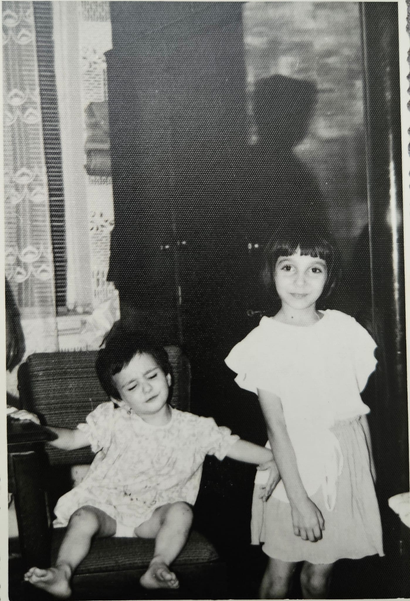 a little girl pushing another girl from the frame