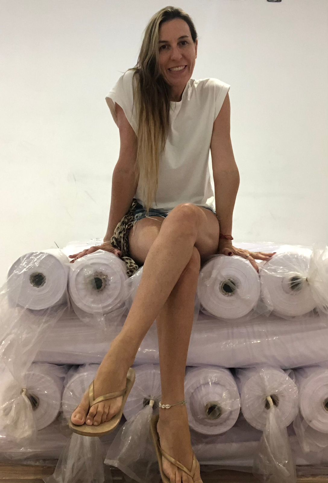 a woman sitting on a pile of rolls of toilet paper