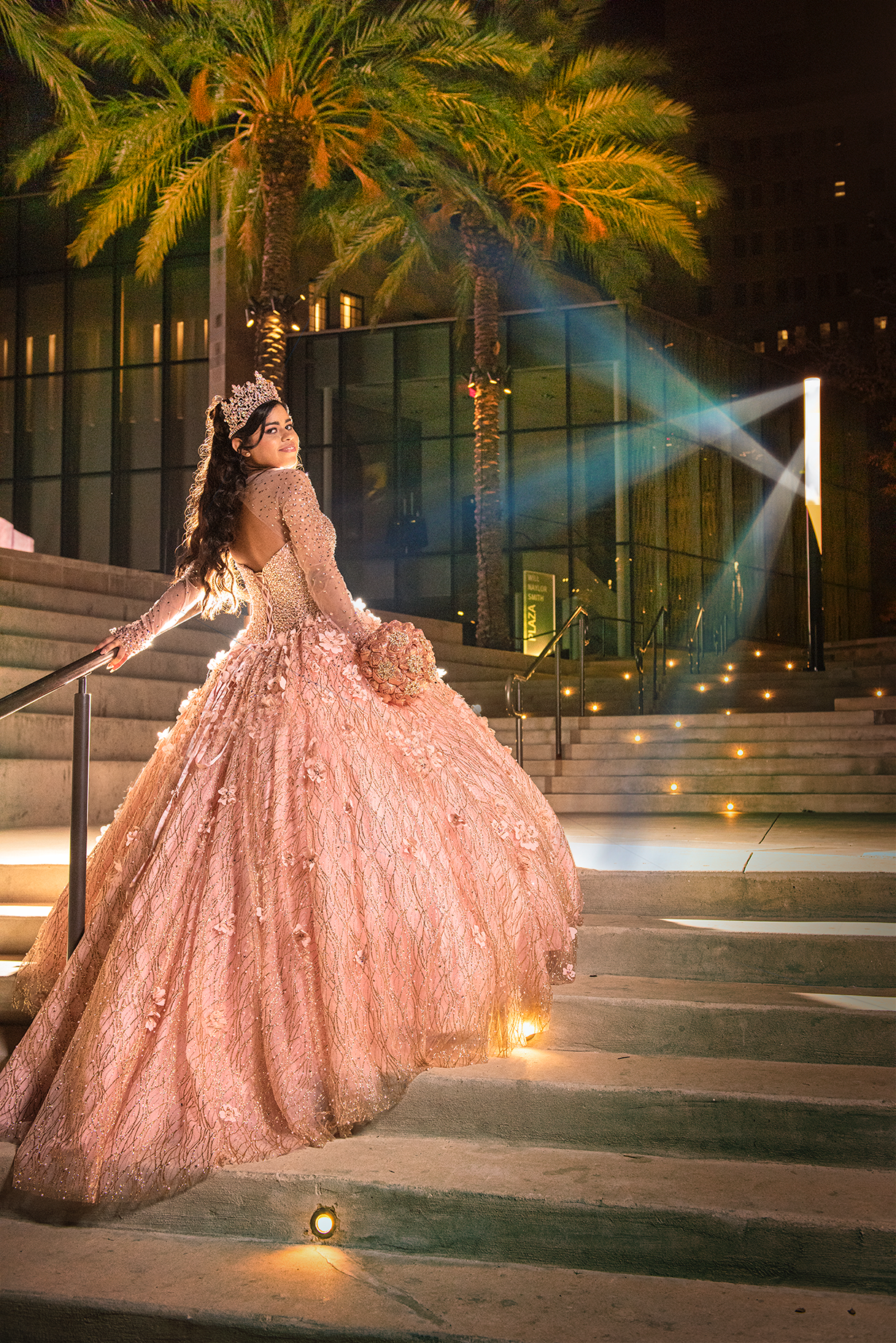 a woman in a pink quinceanera dress and umbrella