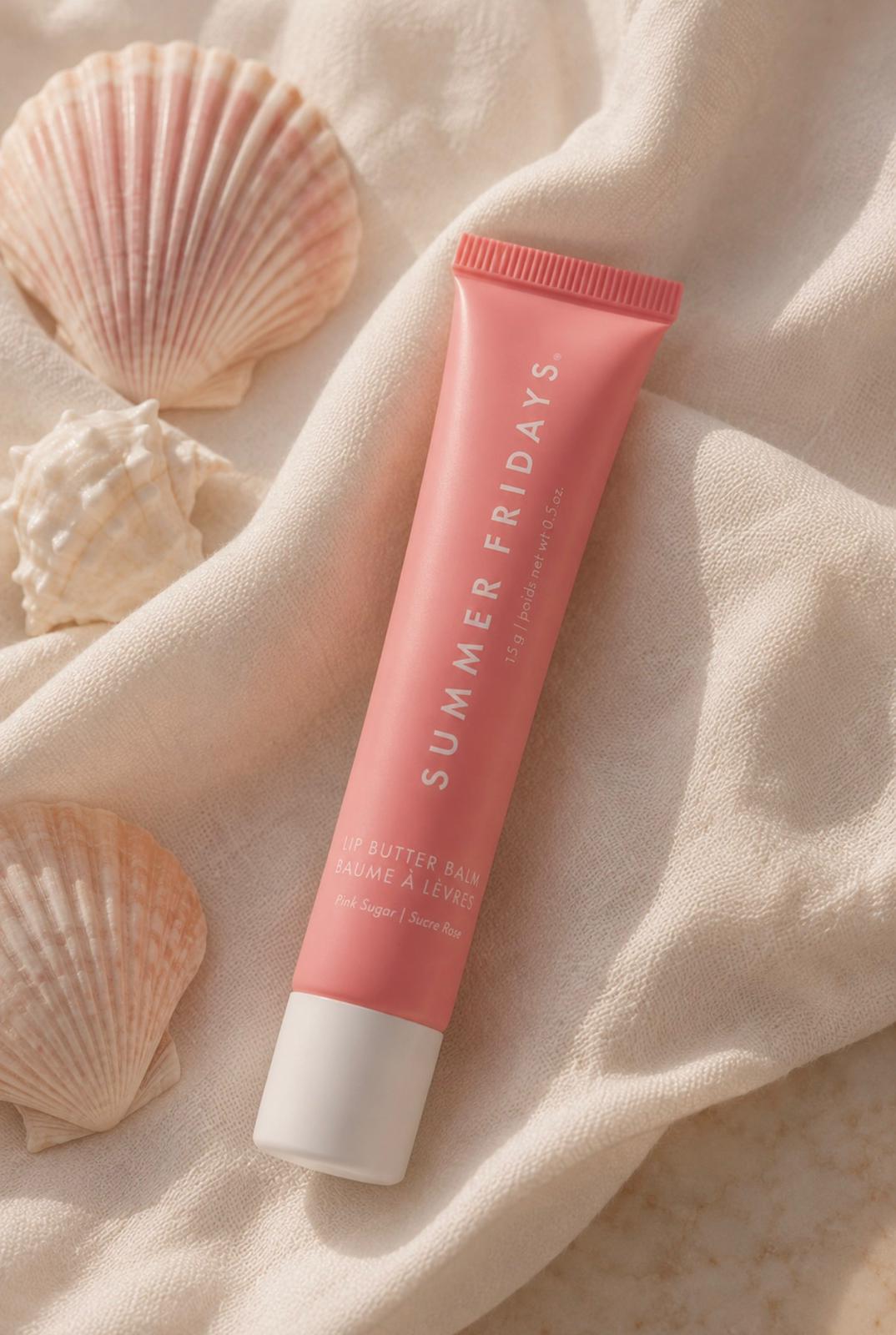 Summer Fridays Lip Butter Balm Pink Sugar on soft cream fabric with seashells in natural sunlight.