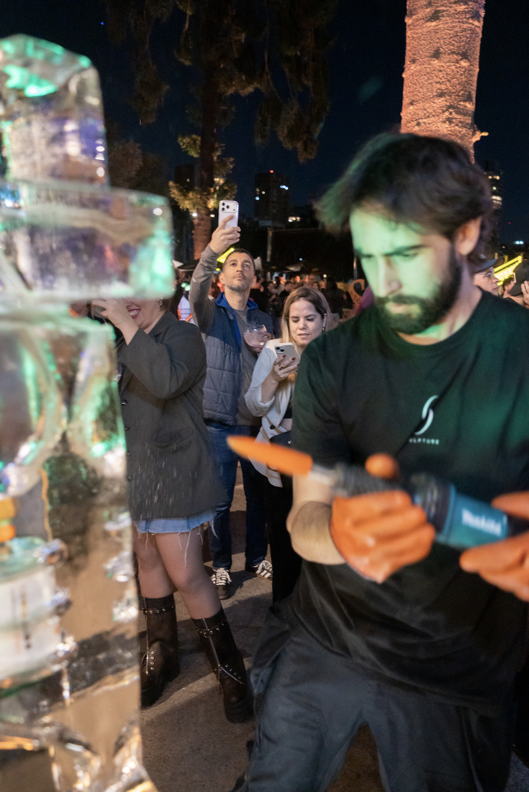 sancho sculpture tallando hielo, personas tomando fotos su celular en un festival en buenos aires