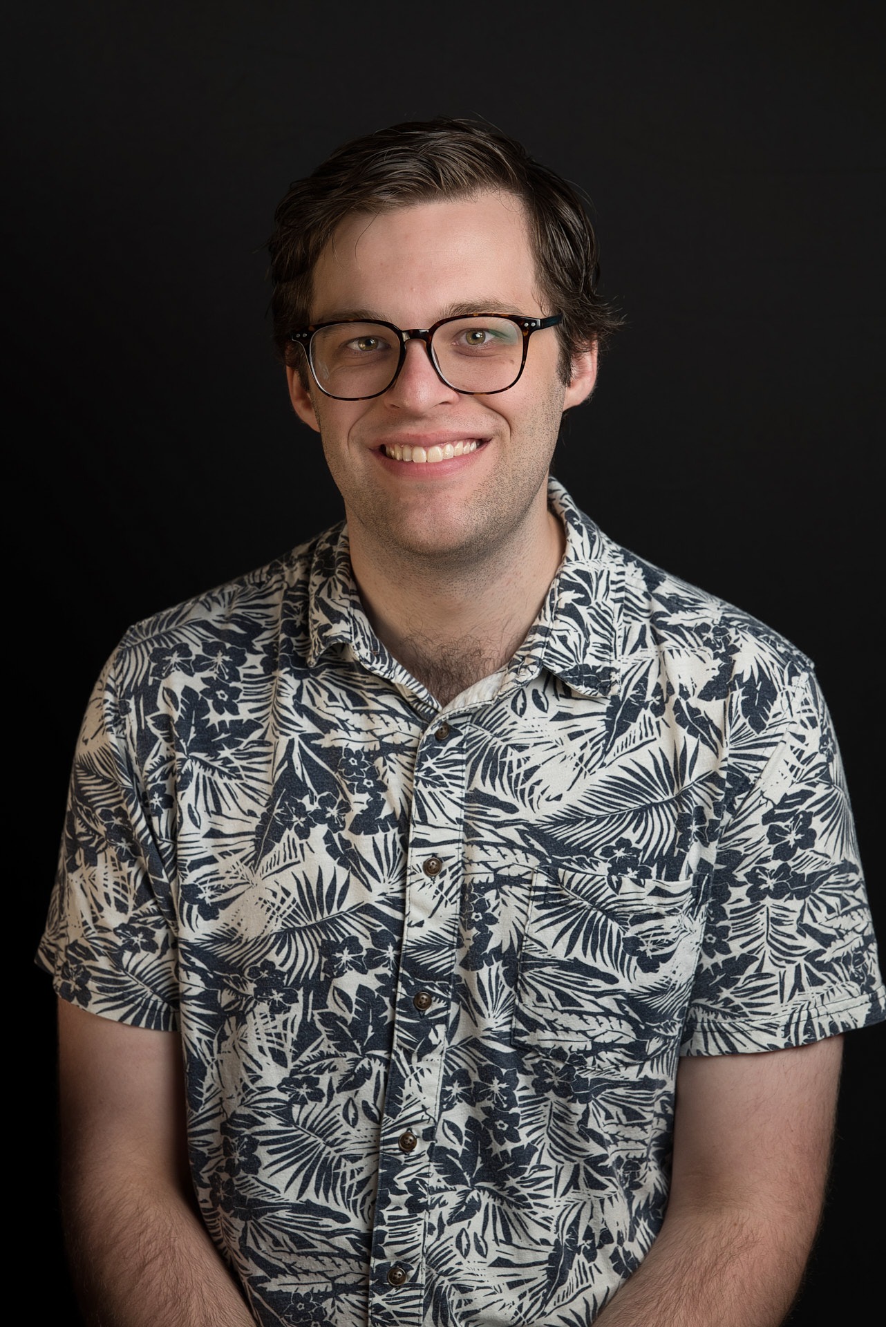 a man in a blue shirt and glasses with big smile