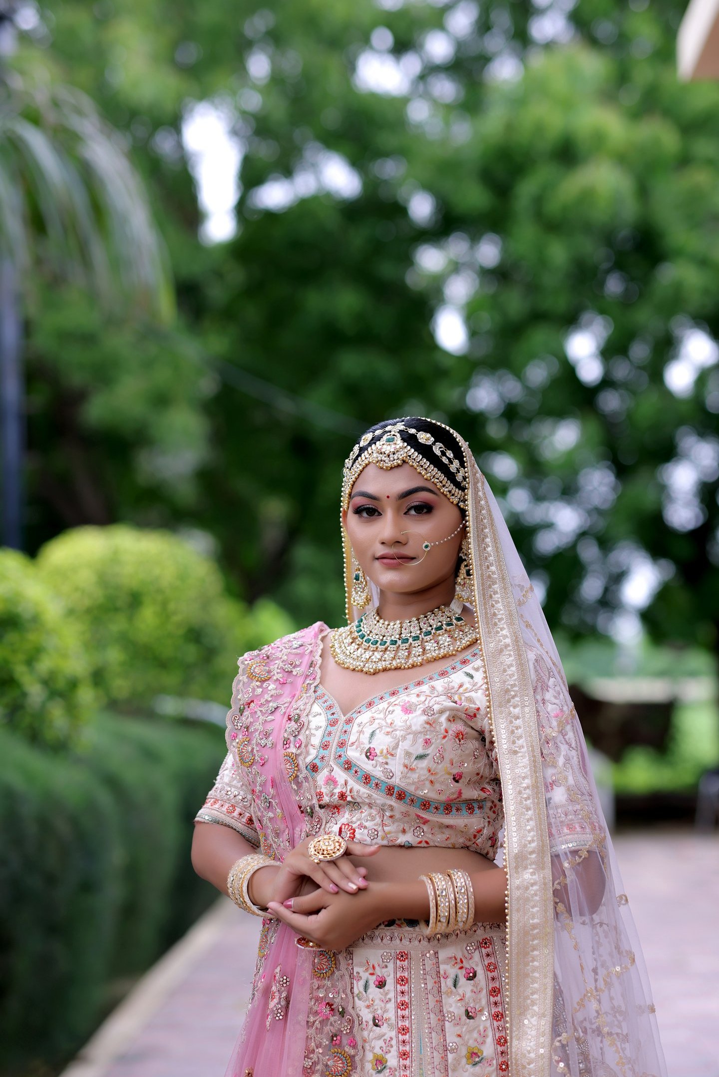 Beautiful bride in pink bridal lehenga with floral embroidery, modern bridal makeup, and heavy 