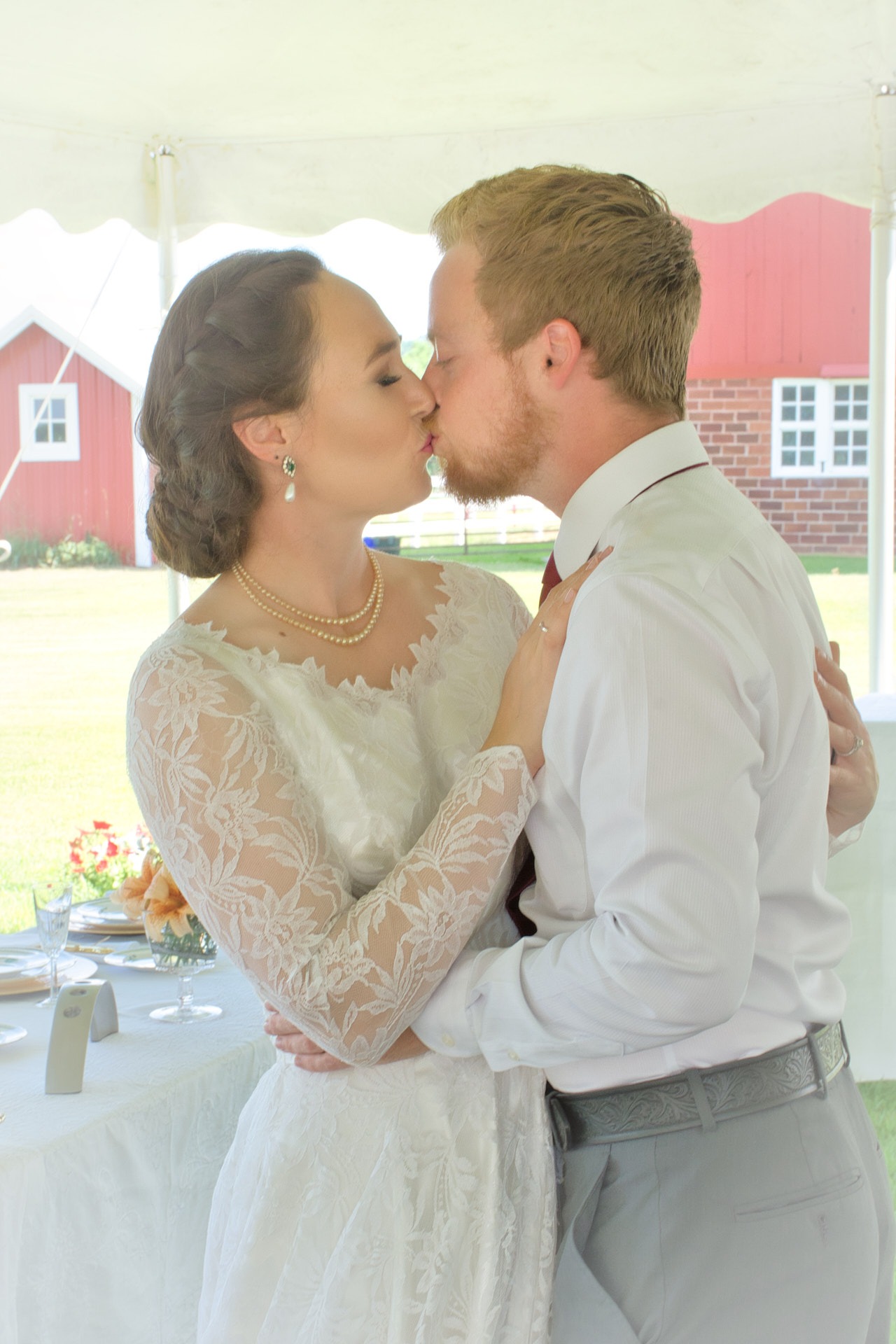 a bride and groom kissing in a tent