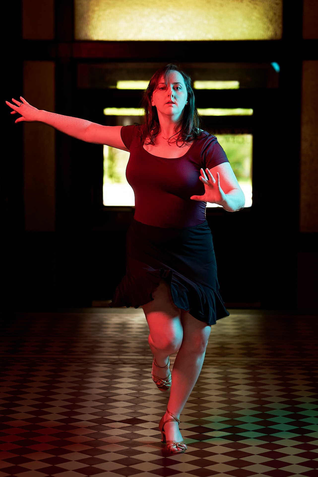 a woman in a black dress dancing in a dark room