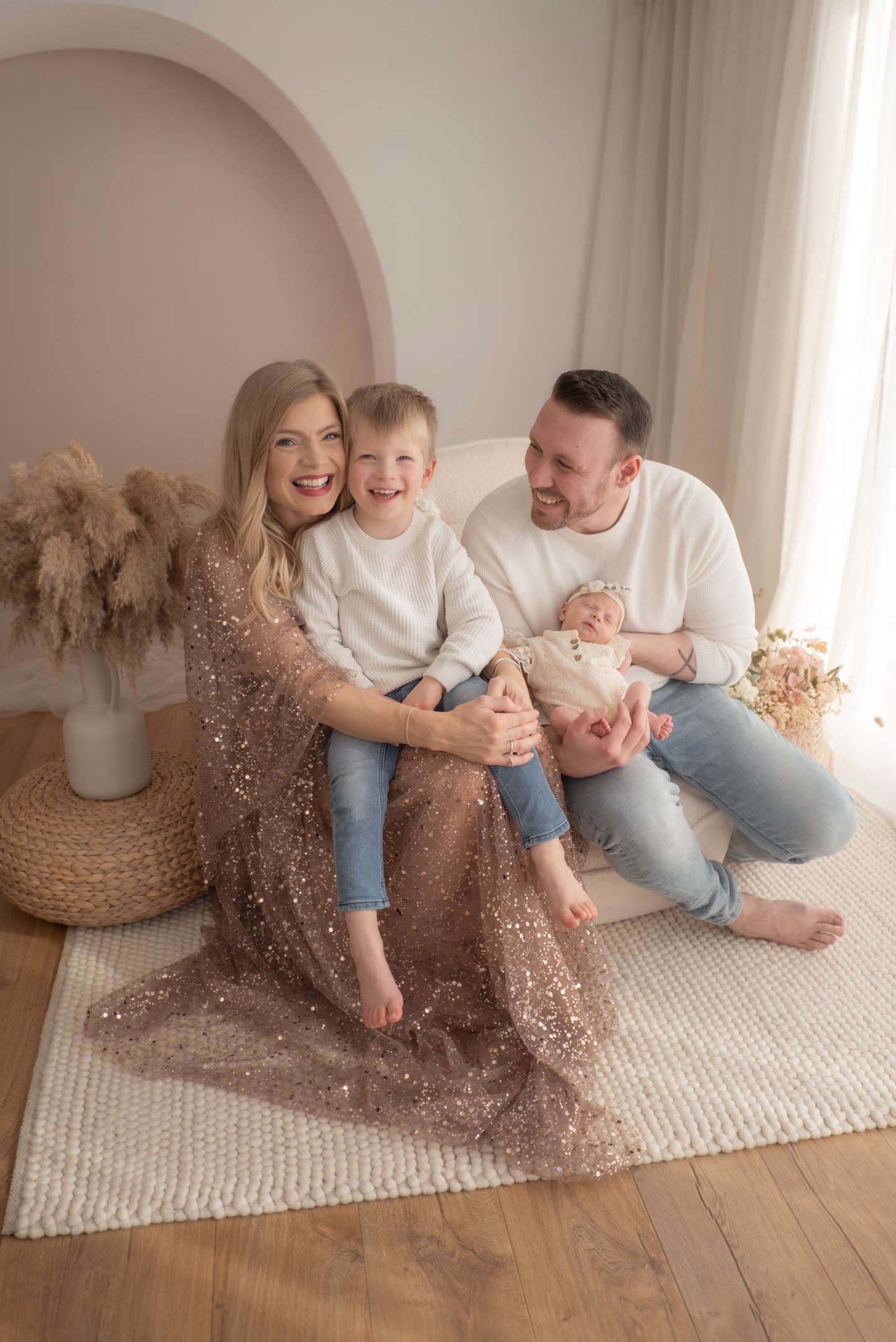 Happy family with a newborn baby posing for a professional indoor lifestyle photoshoot Linconshire