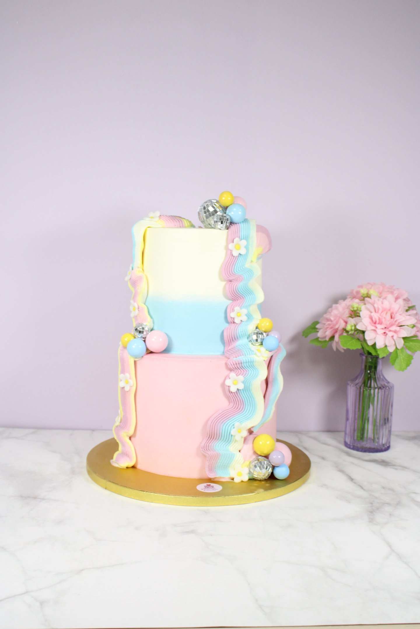 Tarta personalizada de dos pisos con diseño moderno en tonos pastel, creada en Madrid