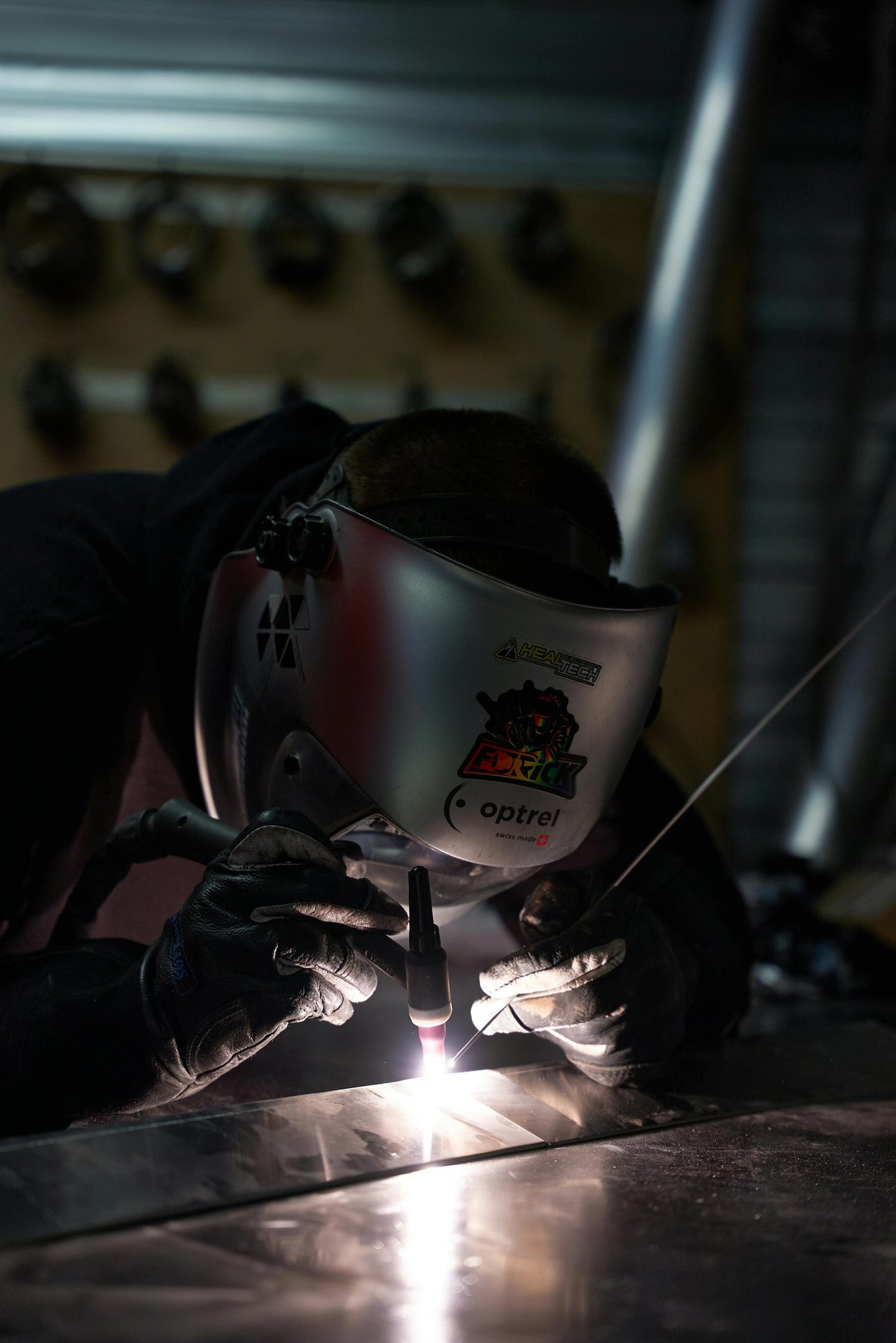 a man welding a metal object in a factory