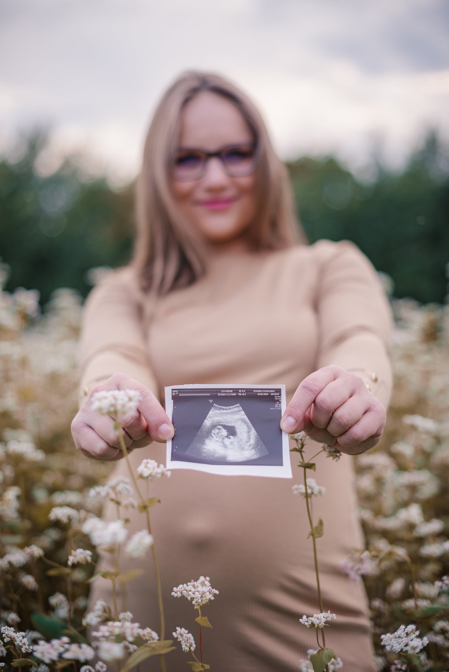 Nėštumo fotosesija - echoskopijos nuotraukytė tarp gėlių