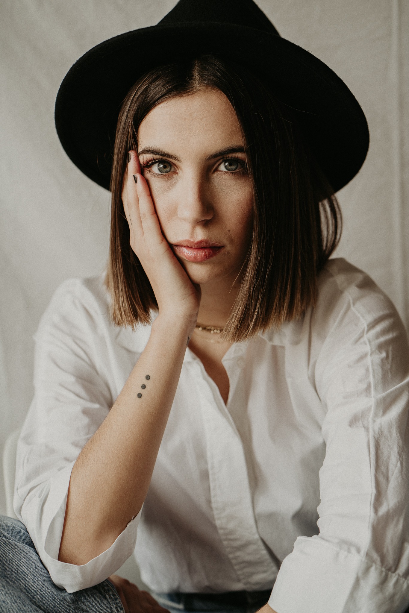 a woman in a white shirt and black hat