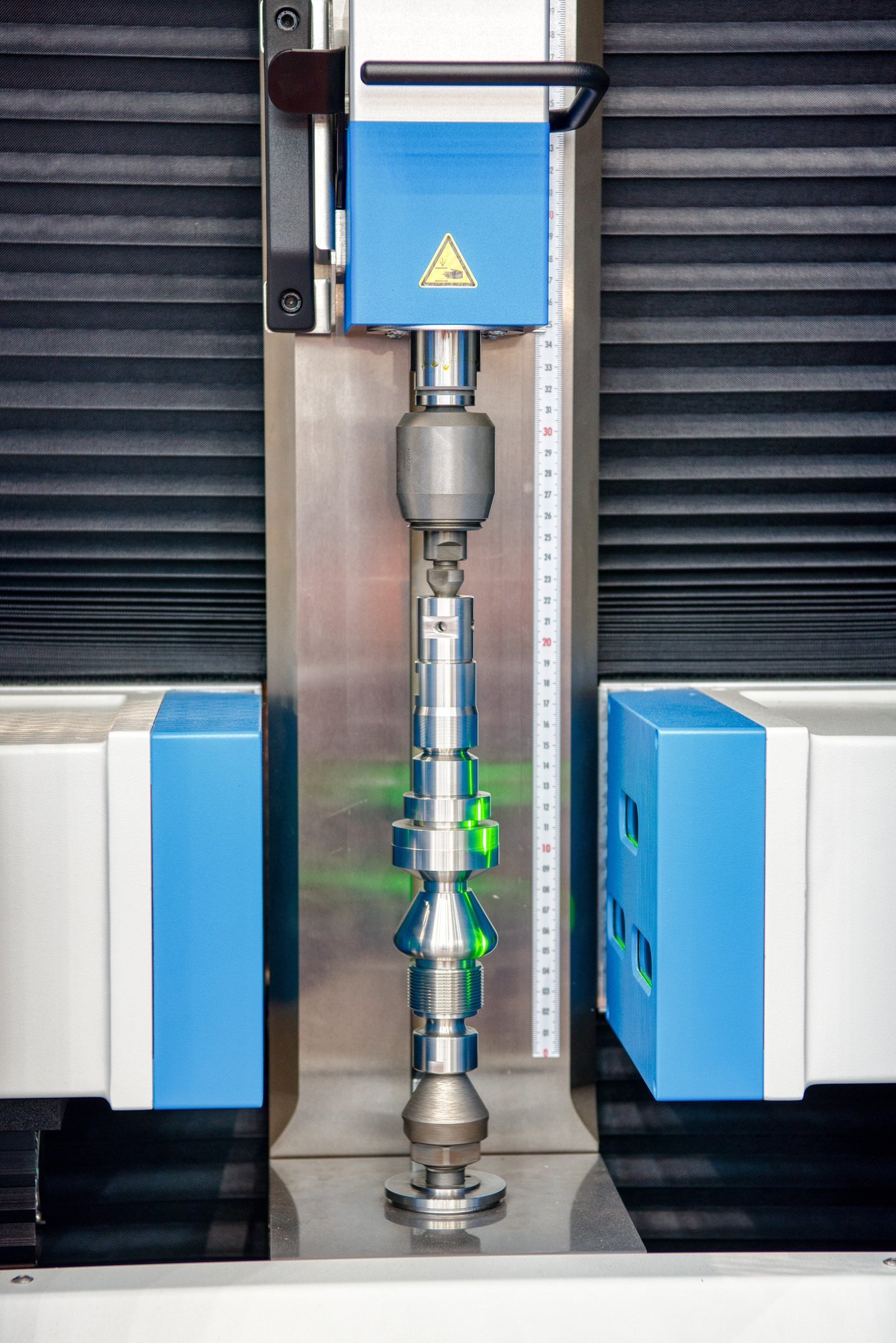 Shaft scanner inspecting a precision shaft using collimated monochromatic light. 