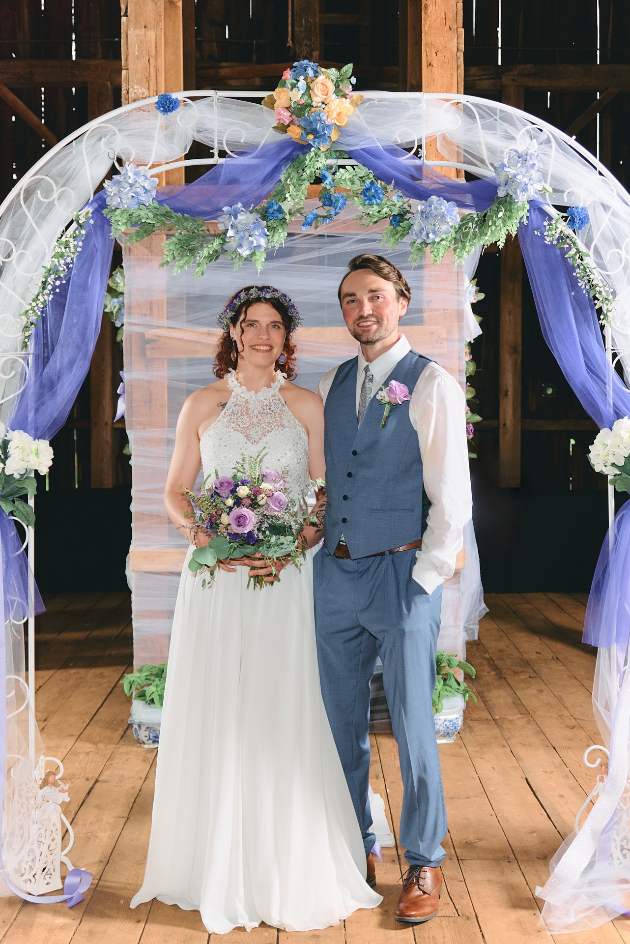 a groom and bride standing in front of a wedding arch