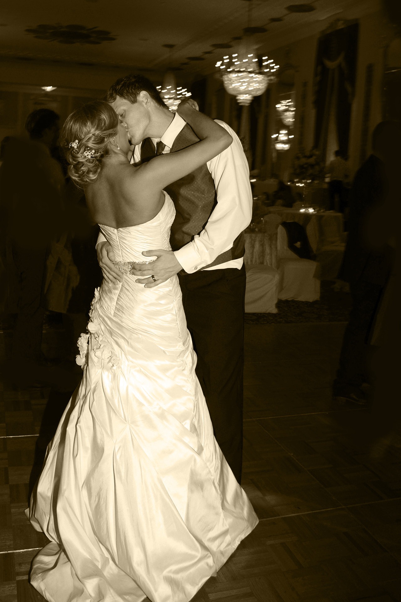 a bride and groom dancing and kissing at their wedding reception in a hotel ball room