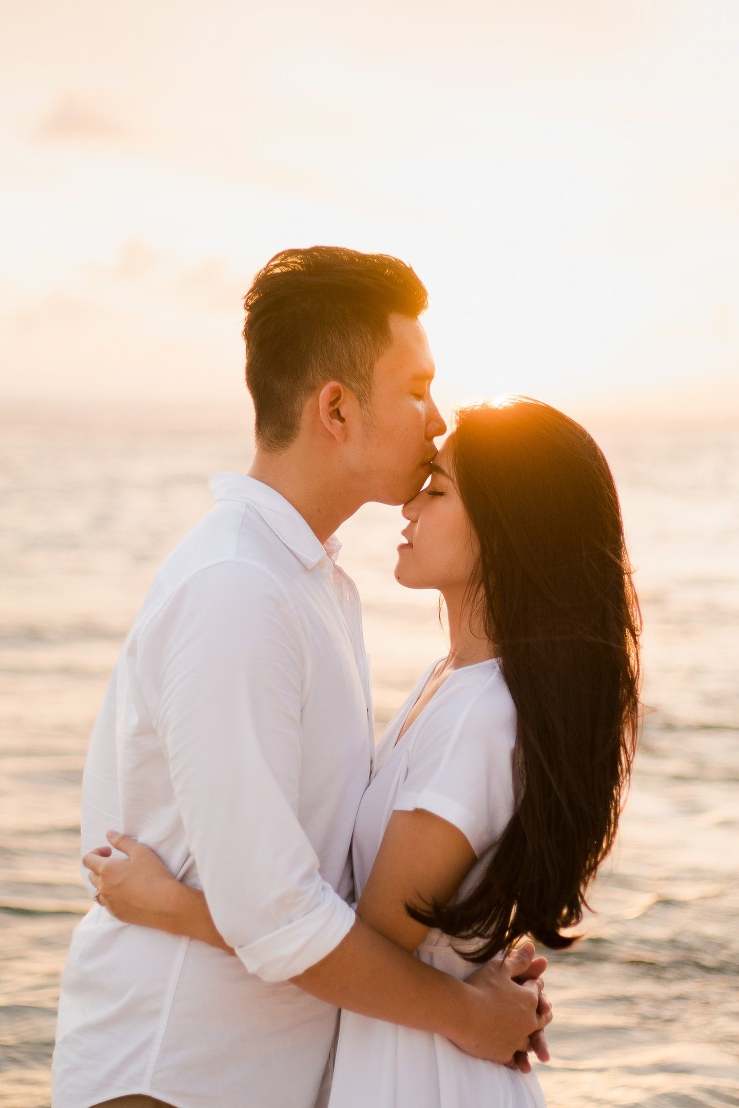Couple embracing during sunset after proposal at Melasti Beach Bali