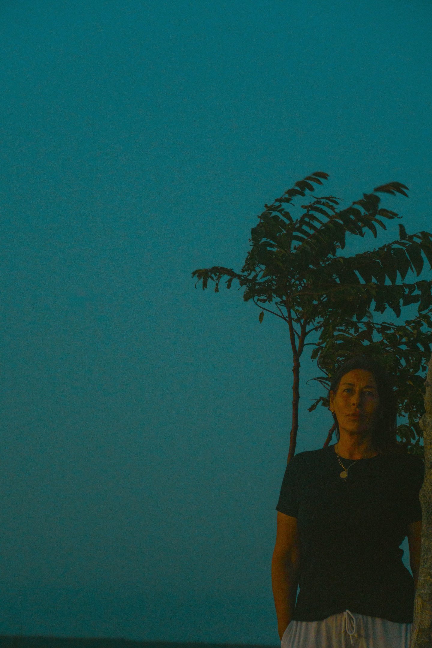 a woman standing in front of a tree