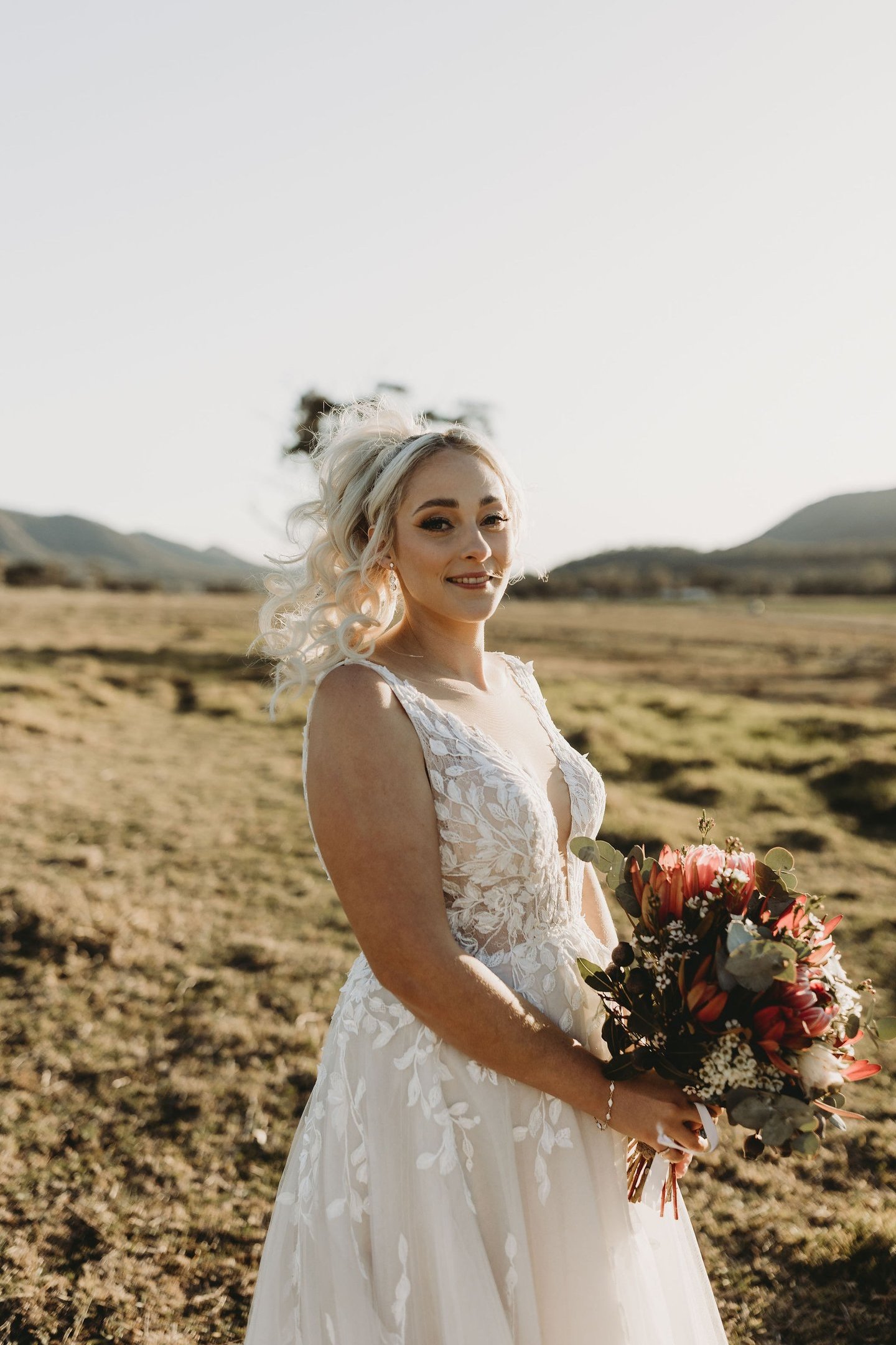 a woman in a wedding dress standing in a field