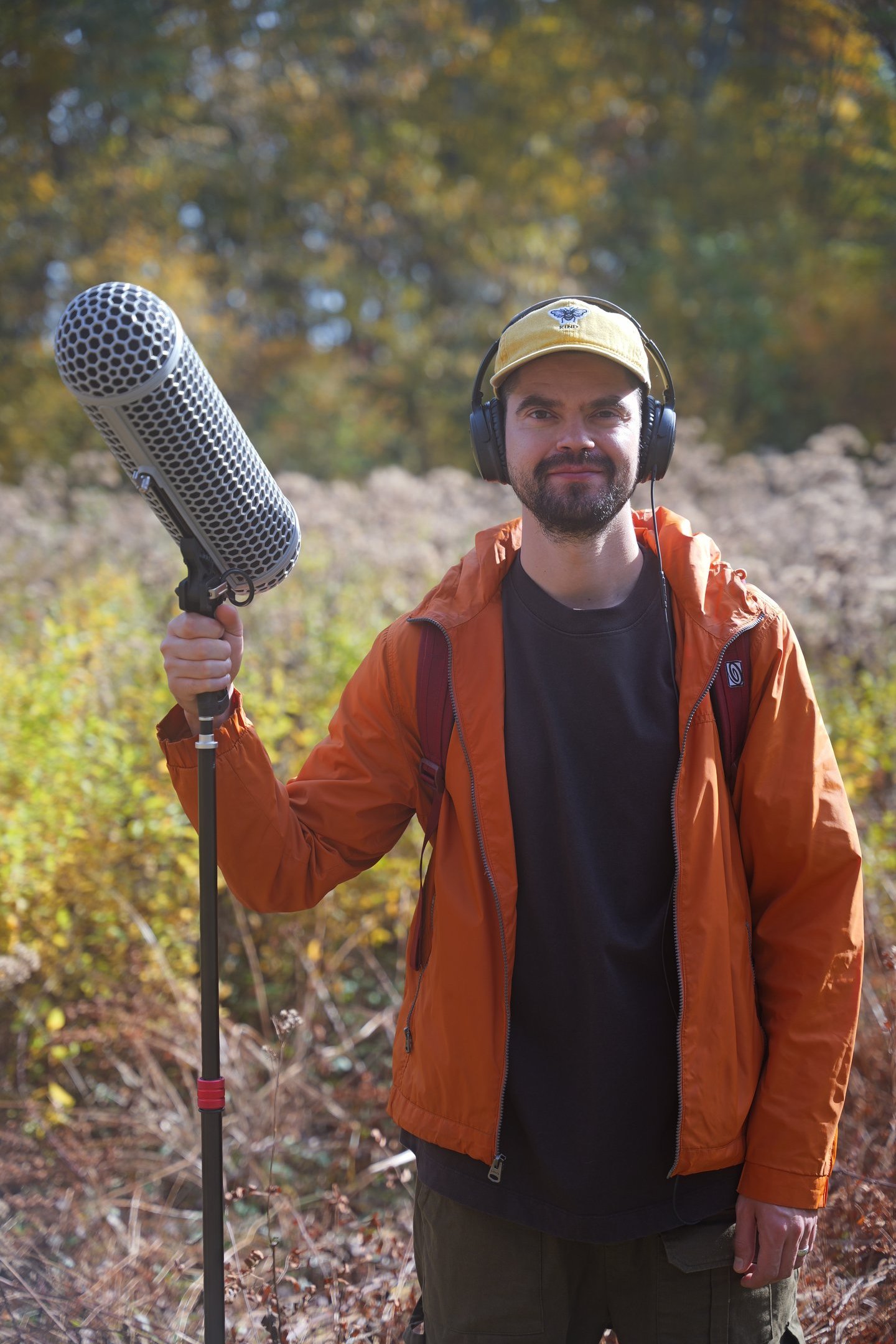 Gene Chaban, freelance sound designer and field recordist, smiling outdoors with a boom mic and head