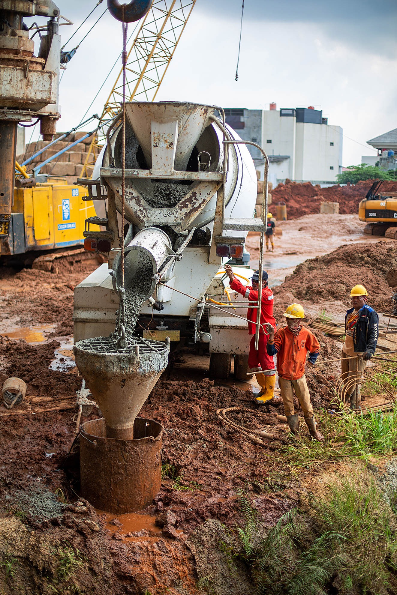 mesin pengaduk semen sedang dijalankan oleh seorang pekerja konstruksi. jasa photography jakarta