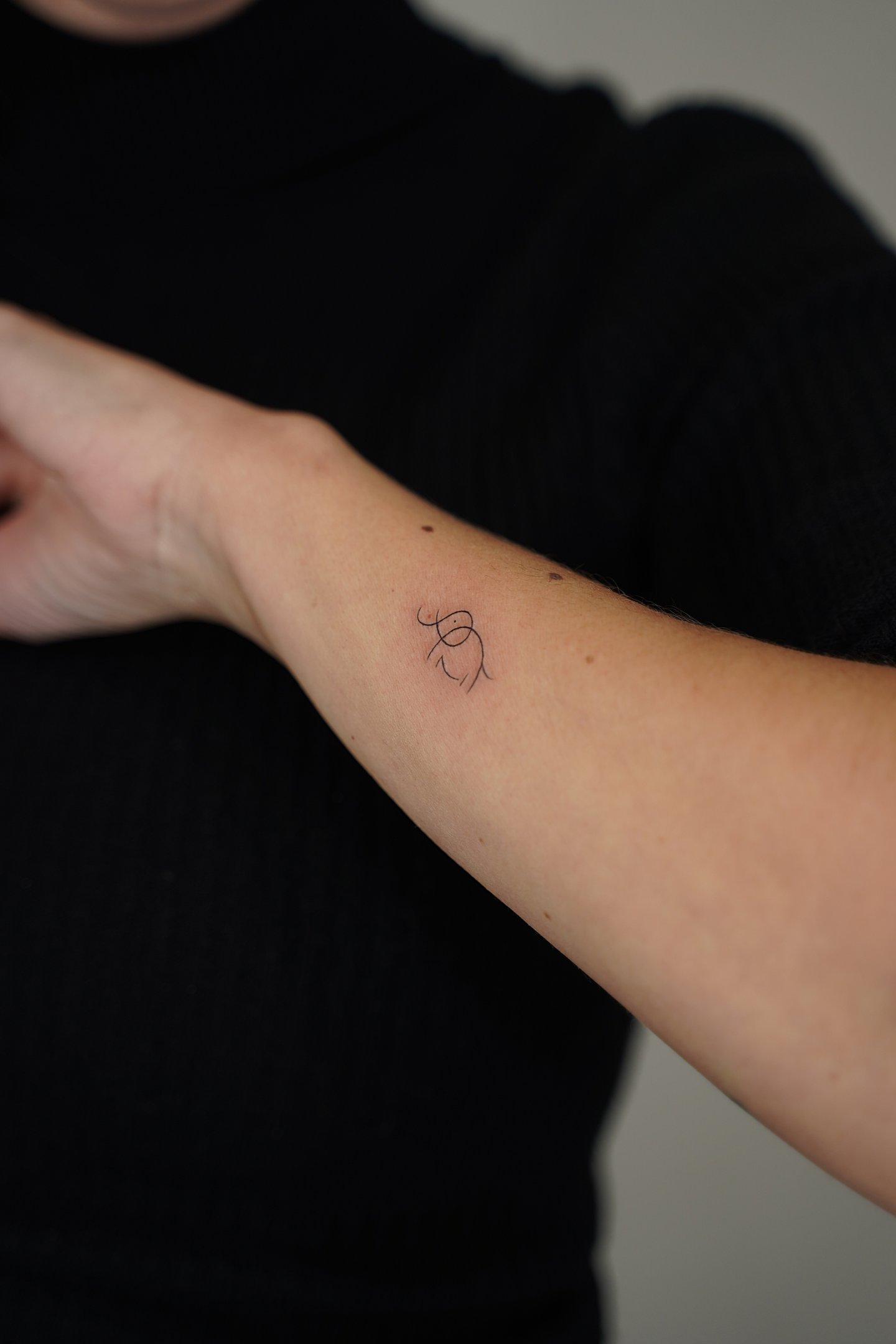 Tatuaje fineline en Madrid de figura abstracta gestual en trazo fino y minimalista en el antebrazo