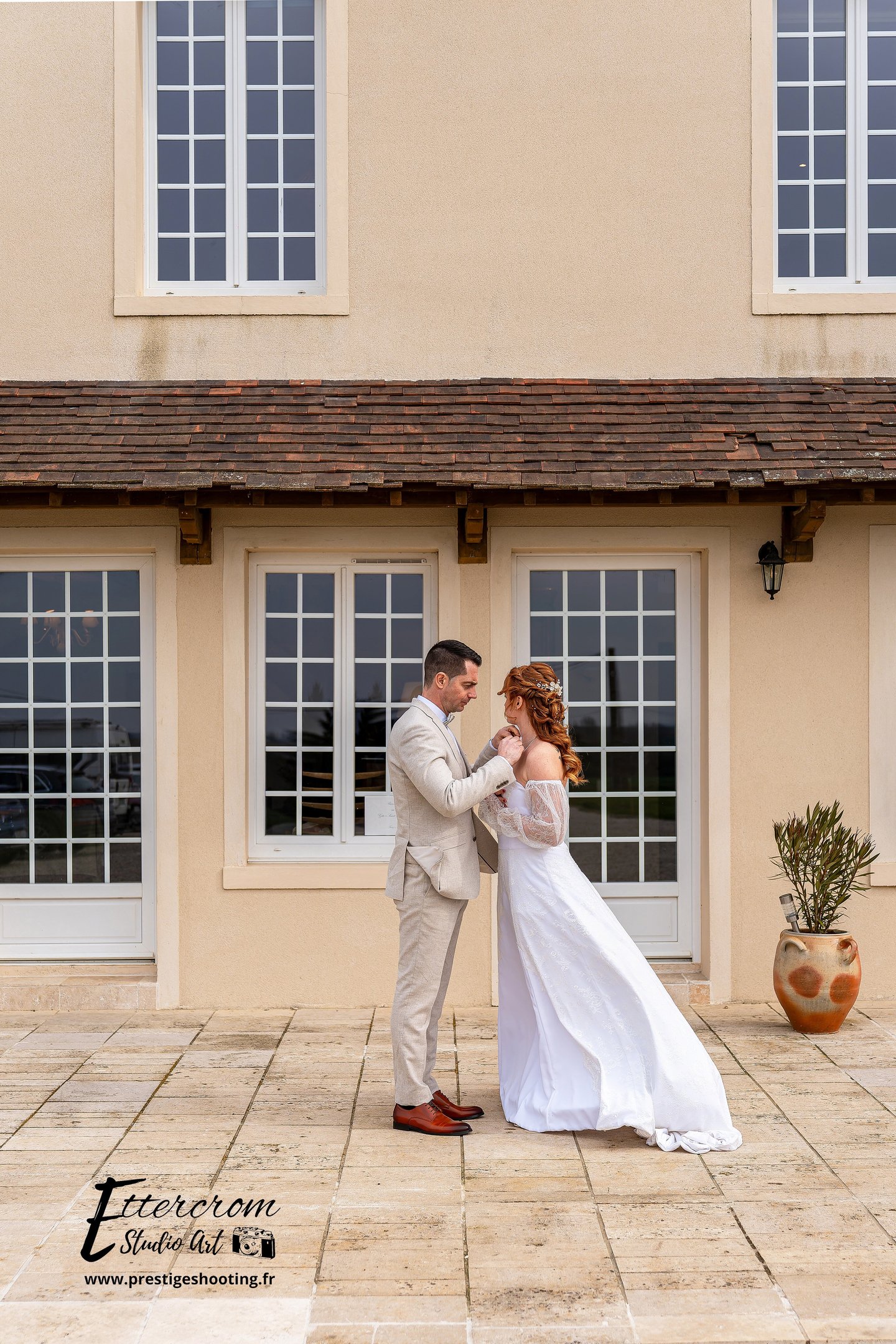 a bride and groom standing in front of a house