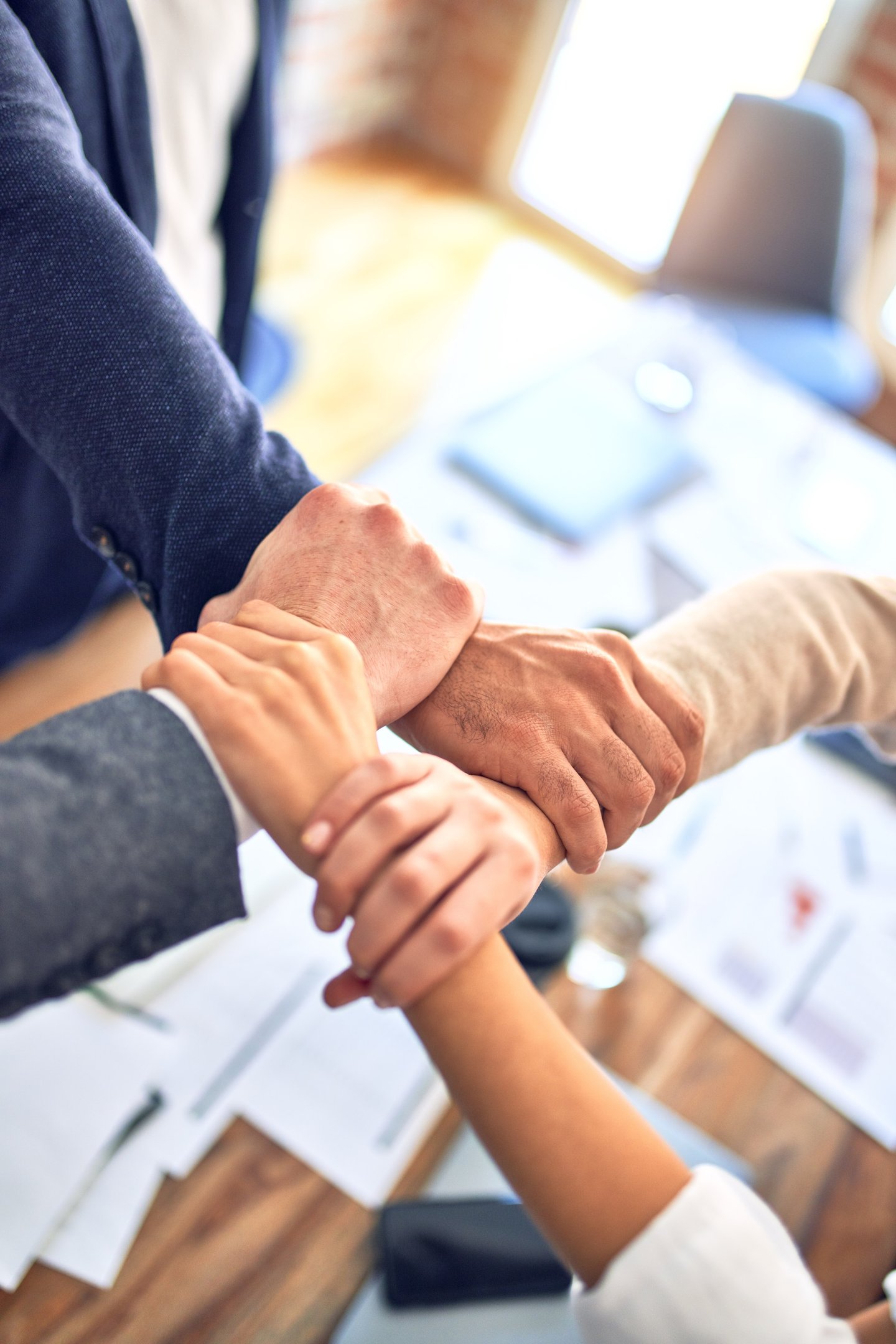 a group of people holding hands in a meeting room