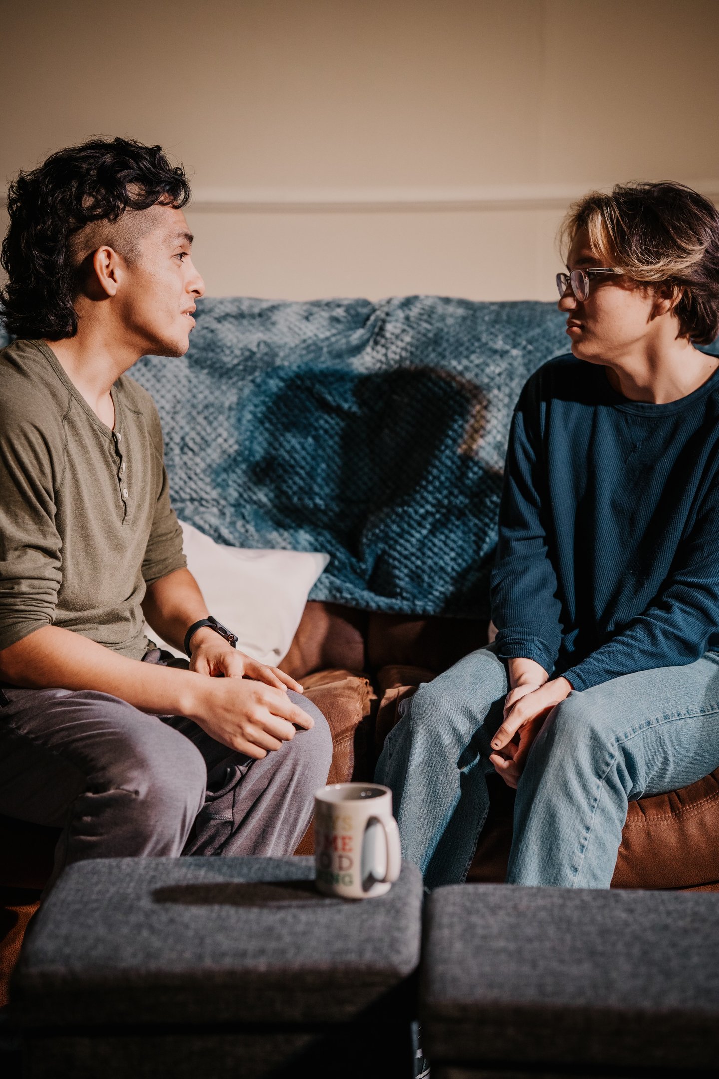two actors sitting on a couch portraying best friends in anew original play by Trent Clifford.