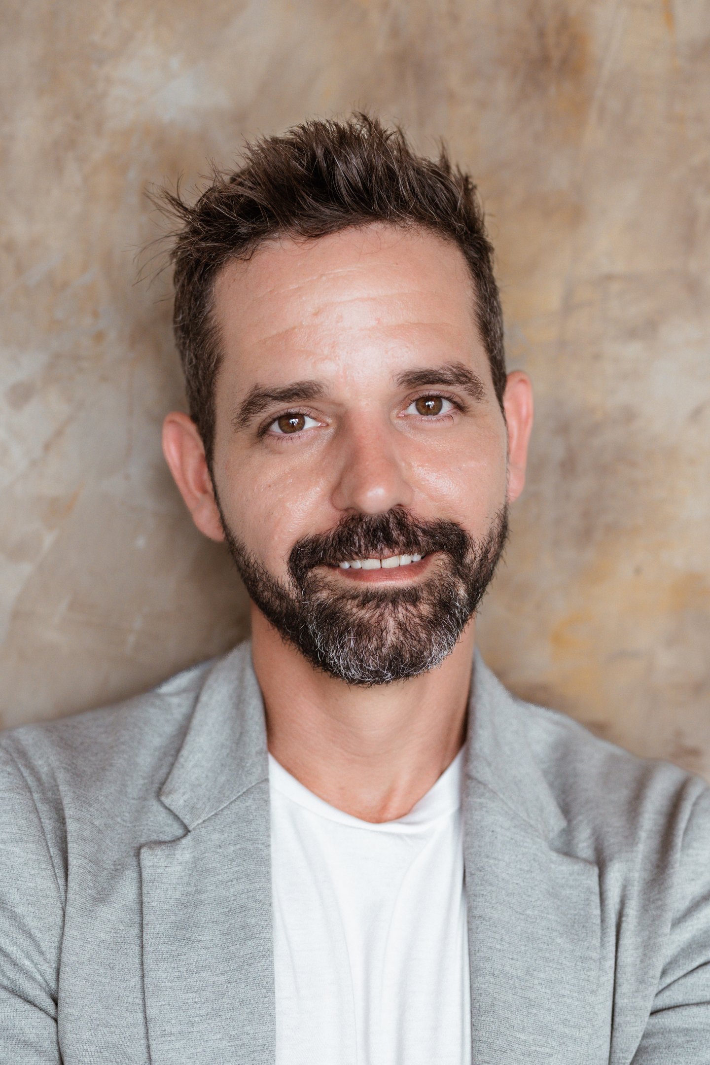 Michael Franco, HR strategist and workplace culture expert, wearing a white shirt and grey blazer in