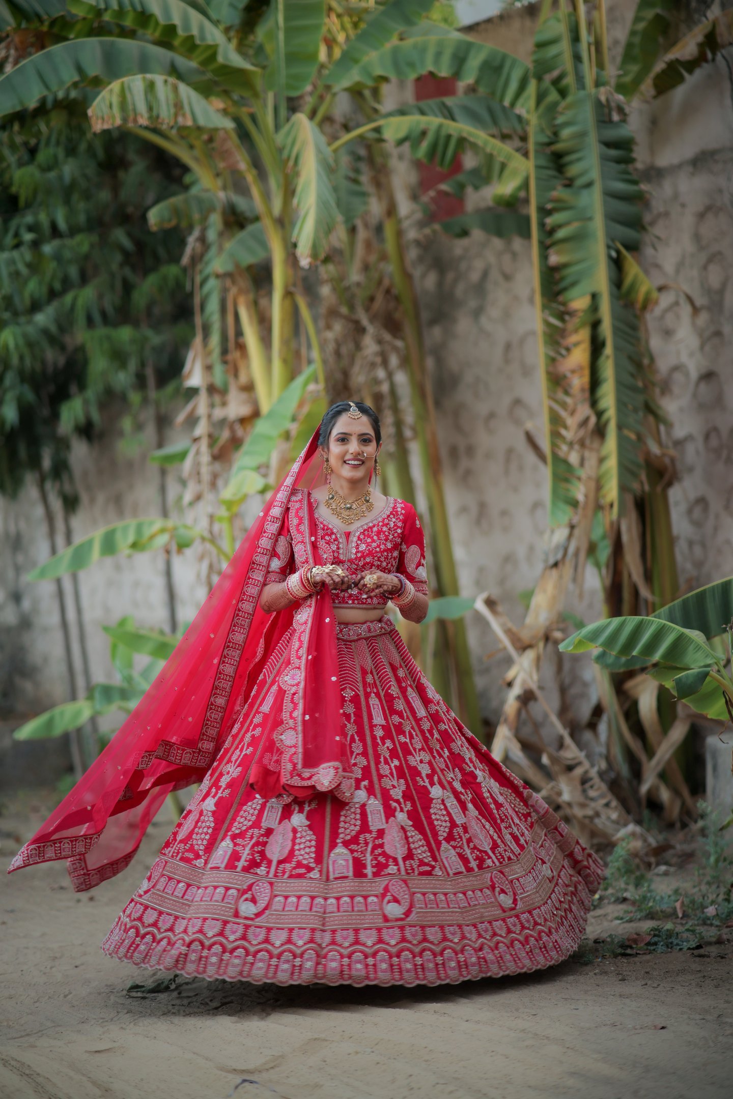 “Bride twirling in red bridal lehenga and choli during wedding photoshoot in Gotri, Vadodara – brida