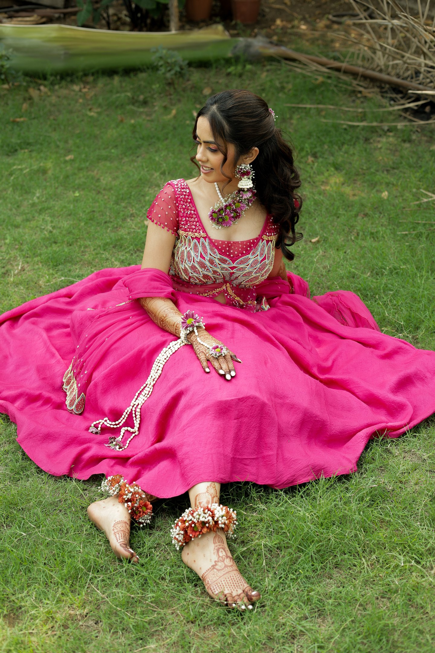  Beautiful haldi bride sitting pose in Vadodara with pink lehenga, bridal makeup and floral jewelry