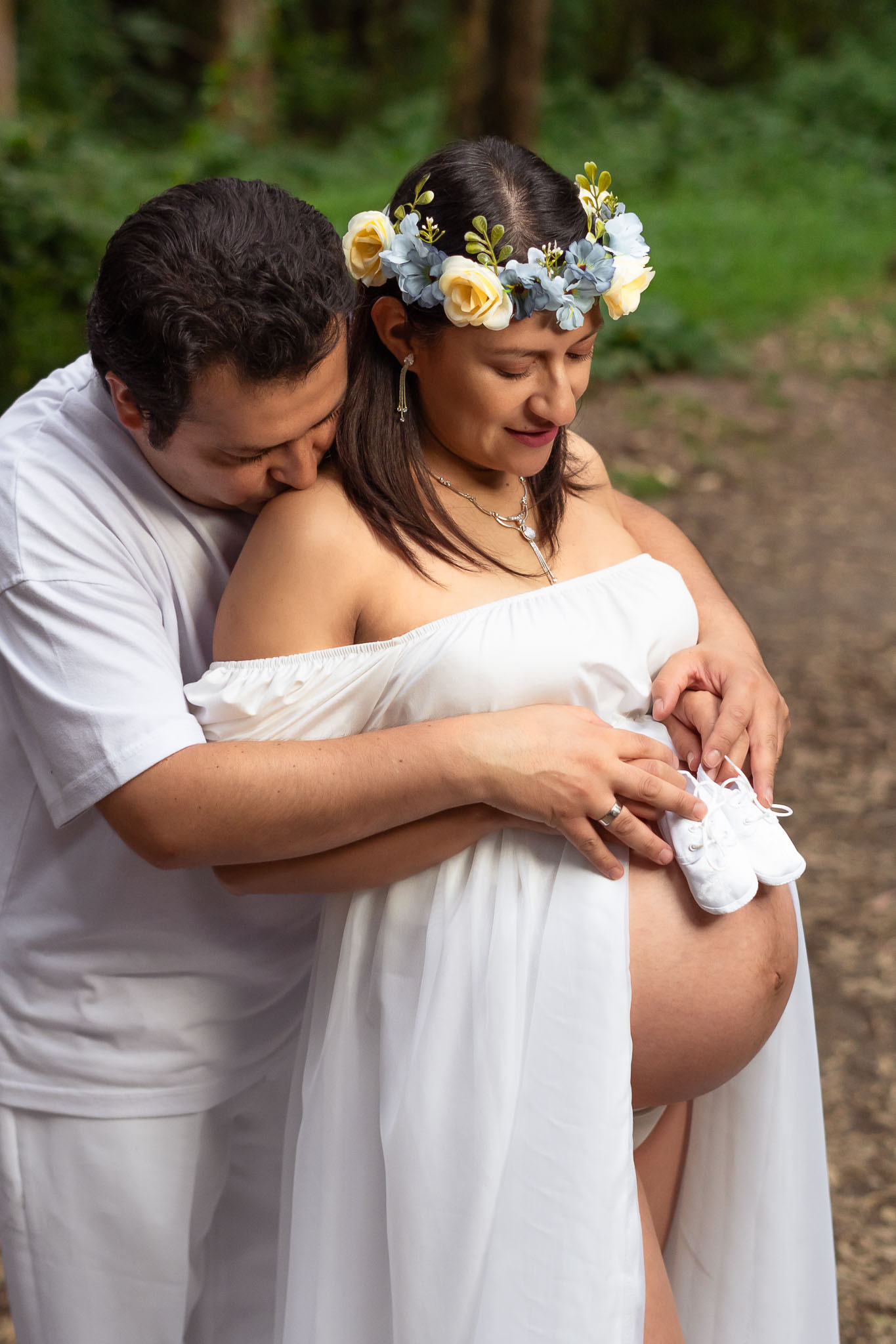 Foto profesional de maternidad embarazo en Quito Ecuador vientre descubierto con zapatos de bebé pareja de esposos