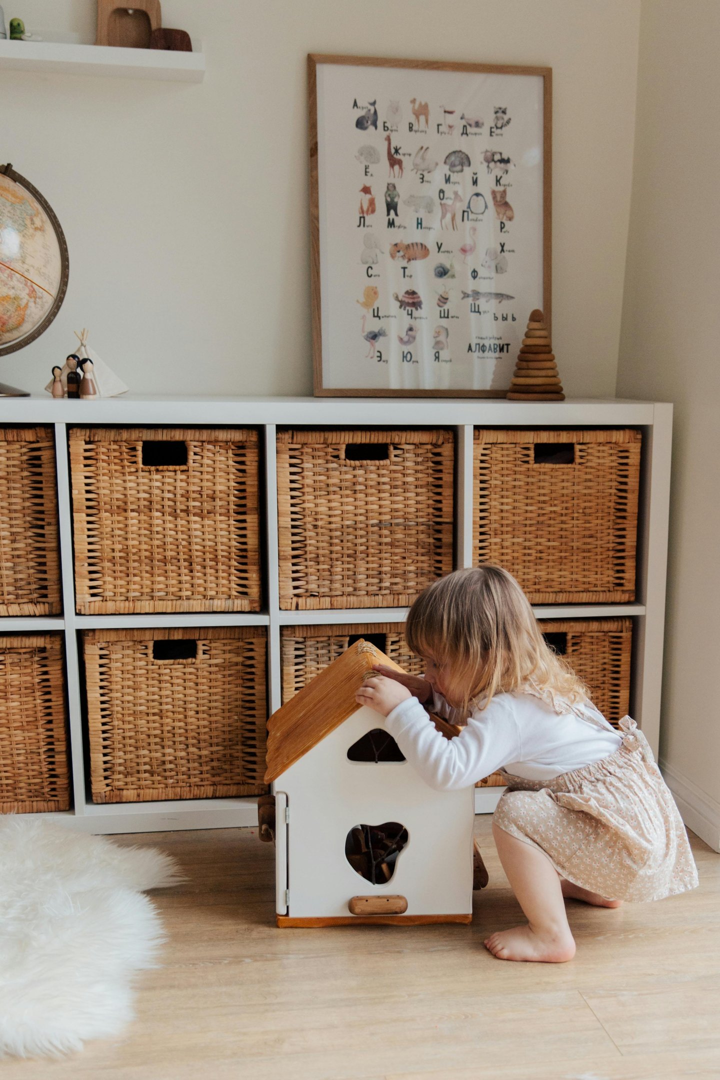 Little girl with play house in front of IKEA Kallax unit with wicker baskets