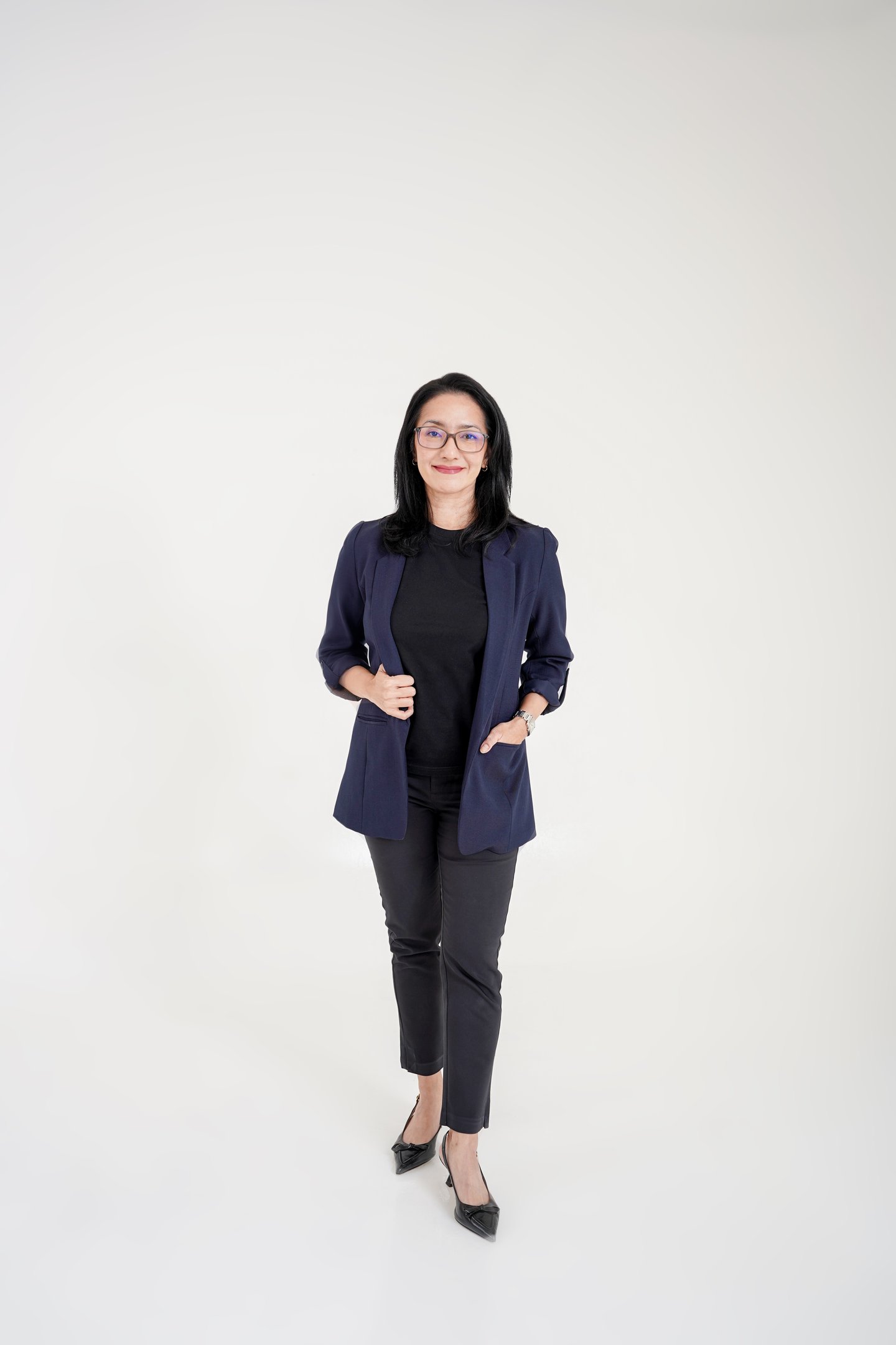 Professional woman in a navy blazer and glasses posing for a business headshot portrait.