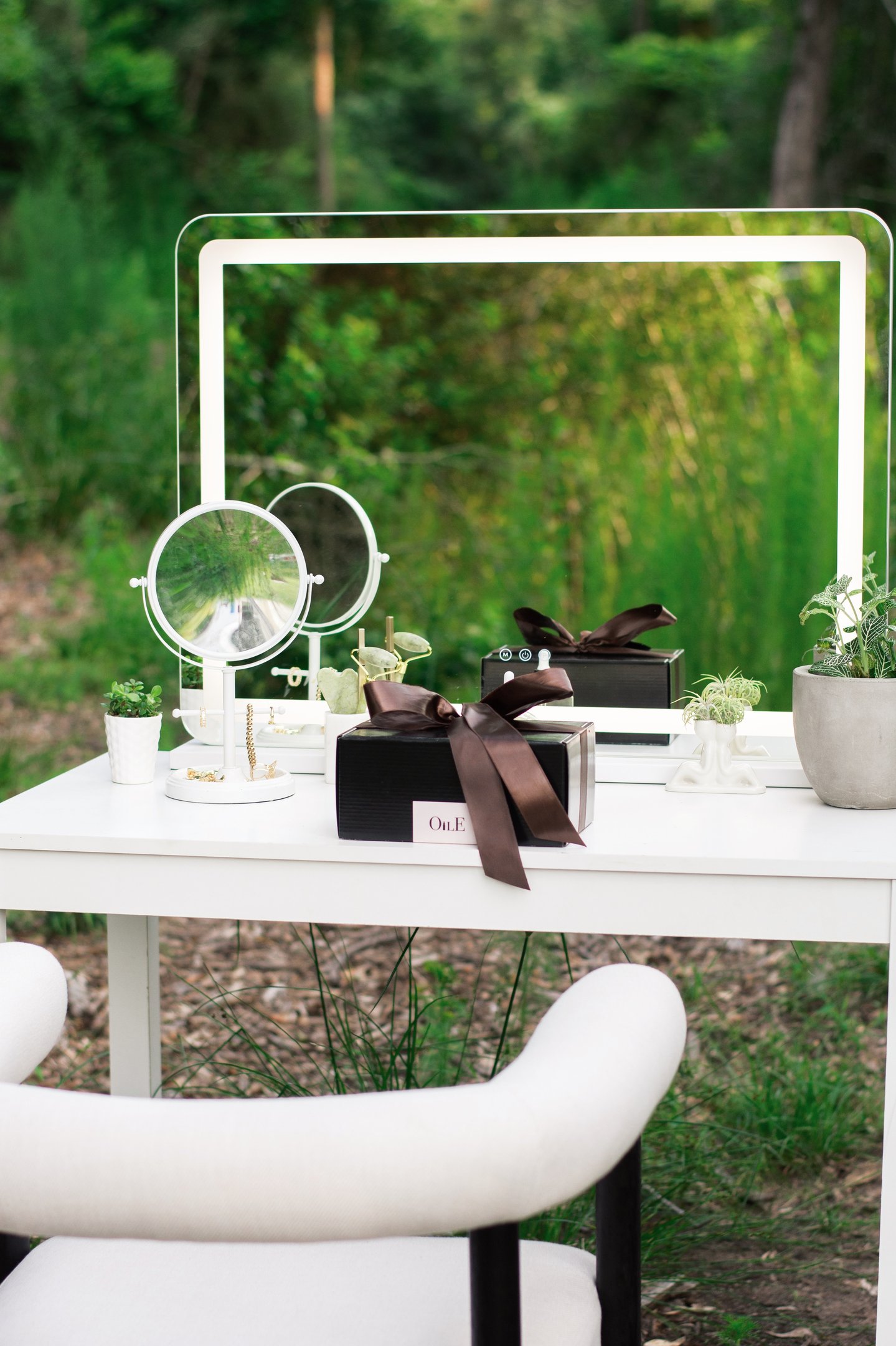 A modern outdoor vanity table with LED makeup mirrors, luxury gift boxes, and jewelry accessories.