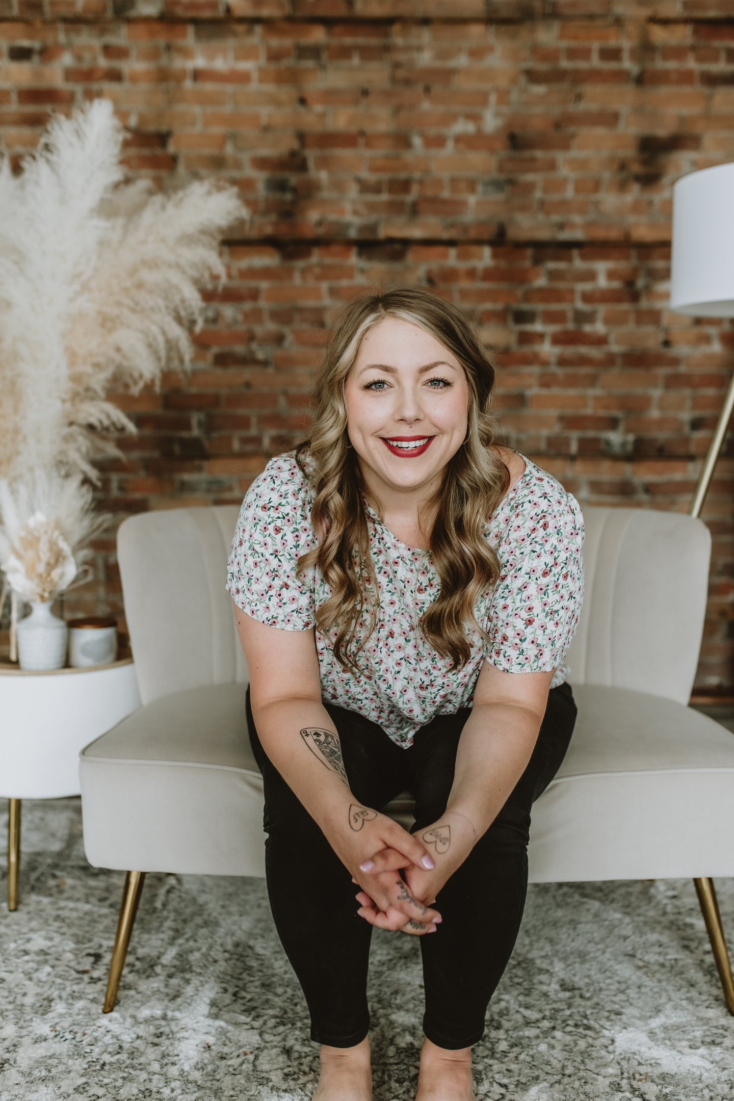a woman smiling while sitting on a comfy white chair