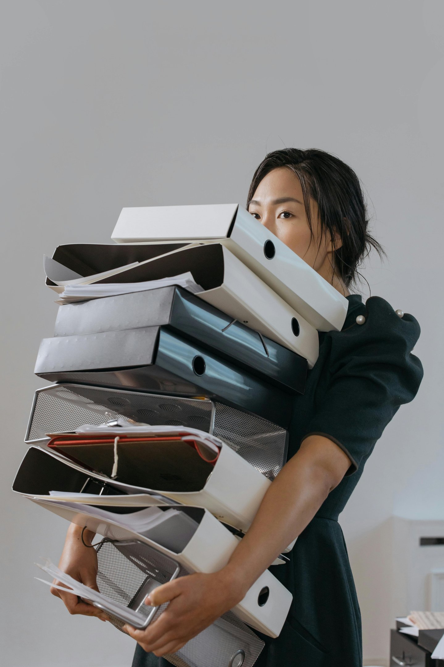 a woman in a green dress, Scientific Editor, holding a stack of scientific papers