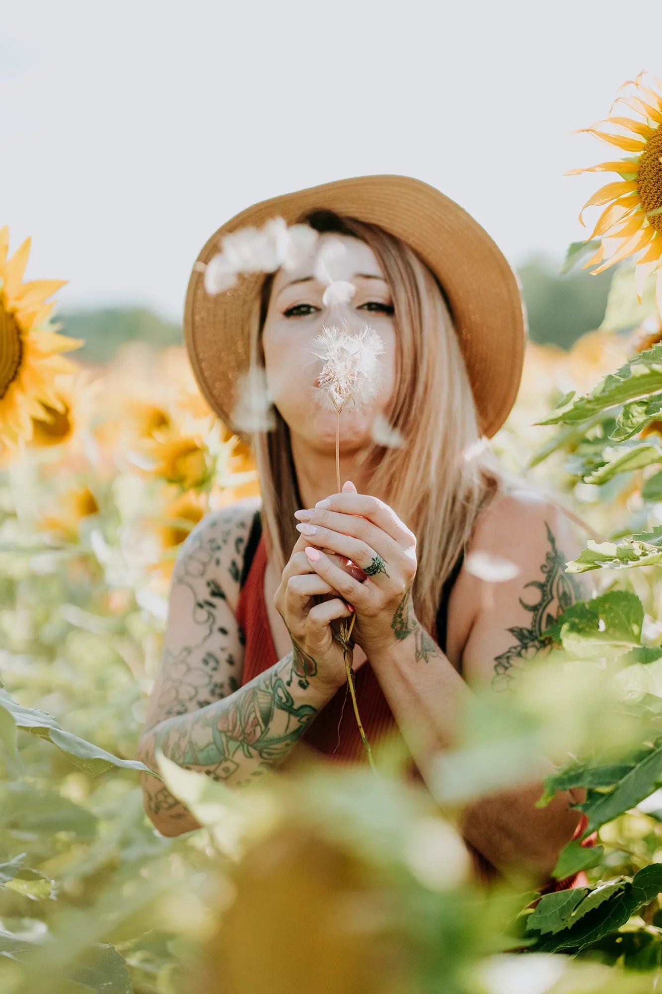 une femme souffle sur un pissenlit