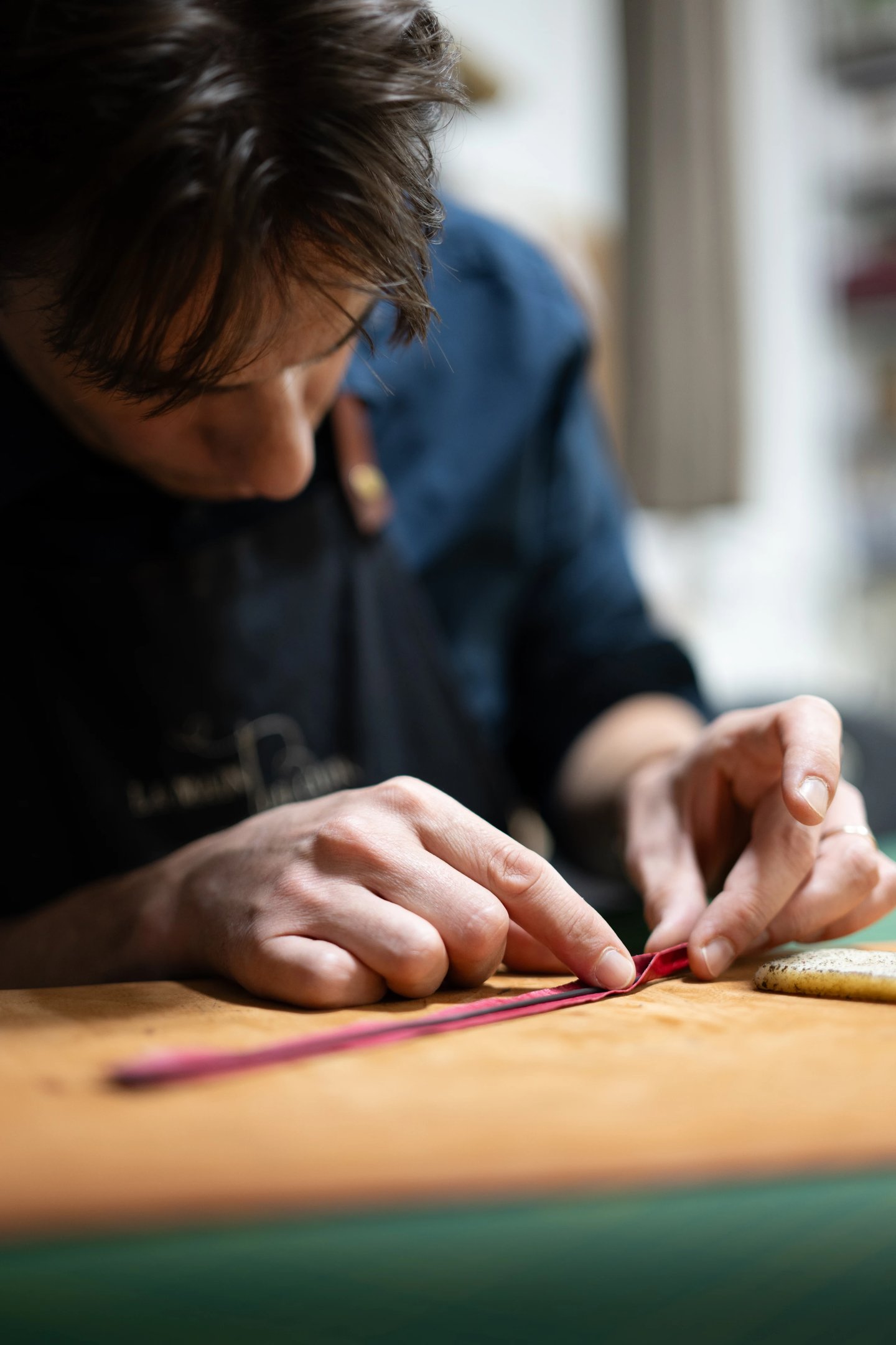 Le maroquinier assemble un jonc en cuir à la main